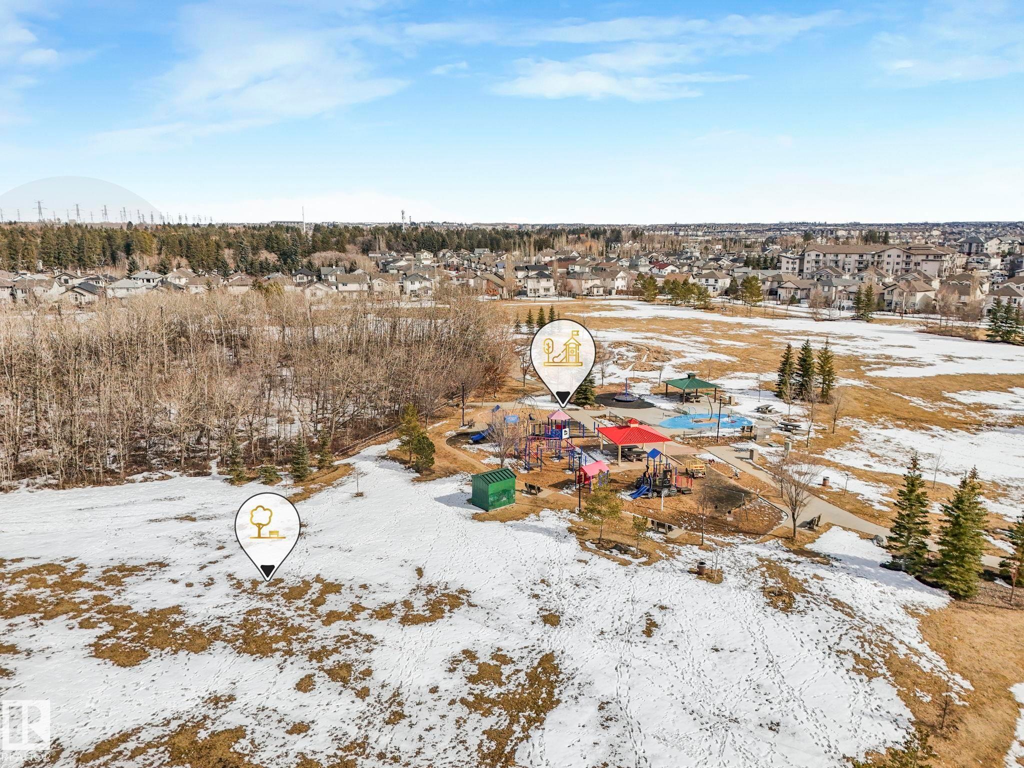 The property is situated within a community featuring a park with playground equipment and a natural area with bare trees - 175 150 Edwards Drive, Edmonton, AB - Outdoor With View