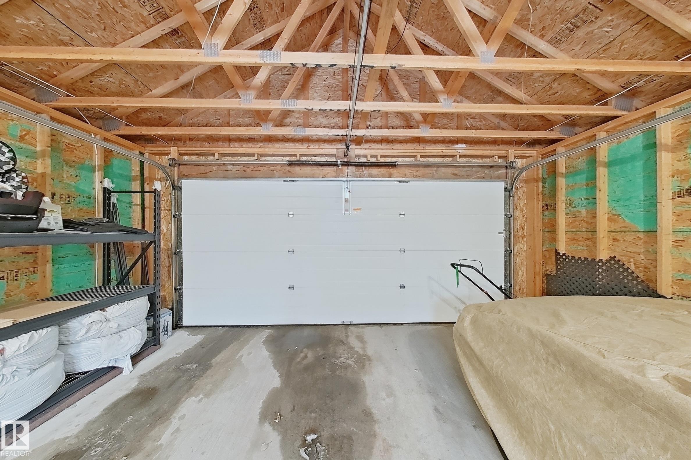 Garage with exposed wood rafter ceiling and concrete flooring - 3609 Weidle Bend, Edmonton, AB - Indoor Photo Showing Garage