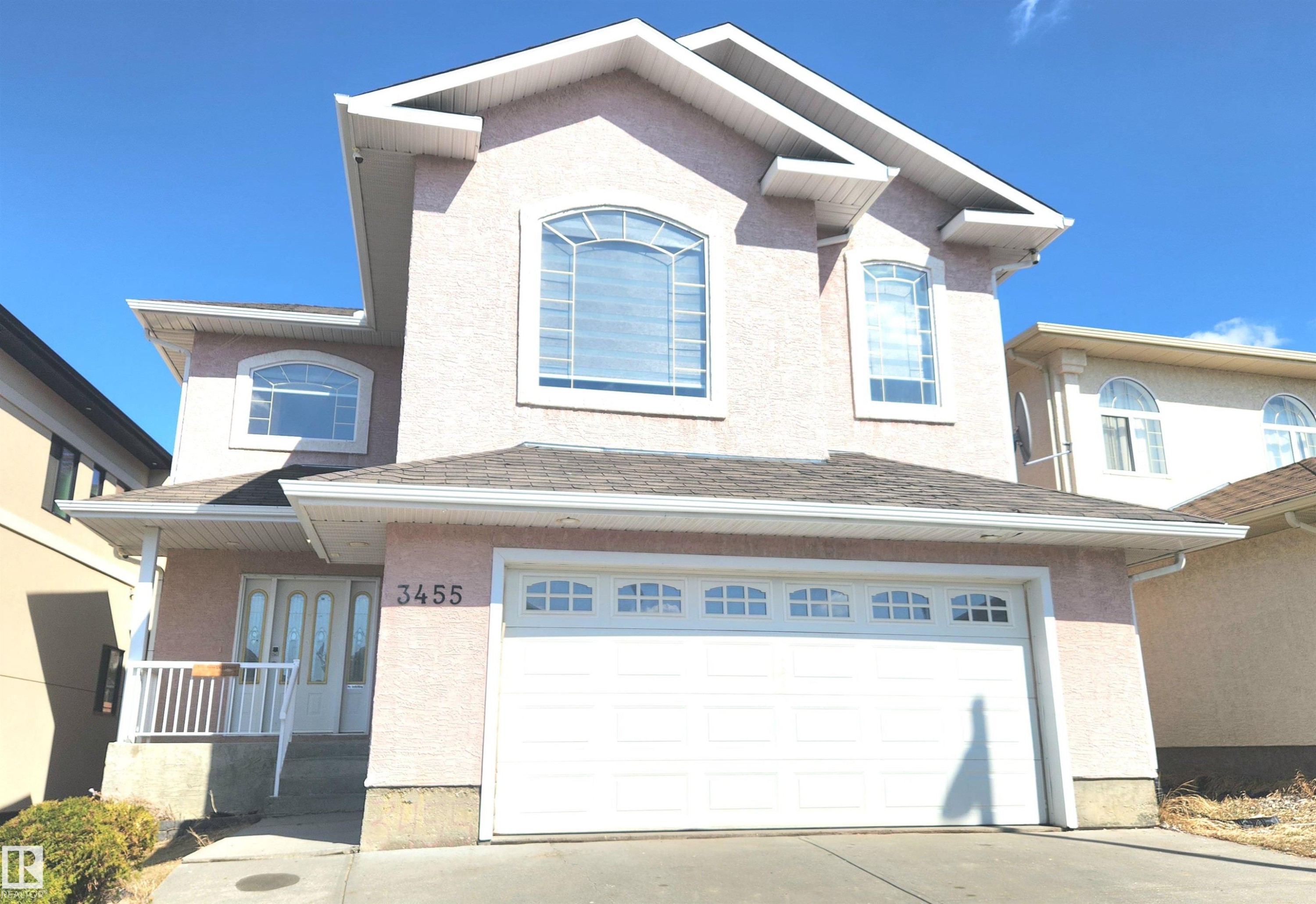 Stucco exterior with a dual garage door and arched window accents - 3455 29 Street, Edmonton, AB - Outdoor
