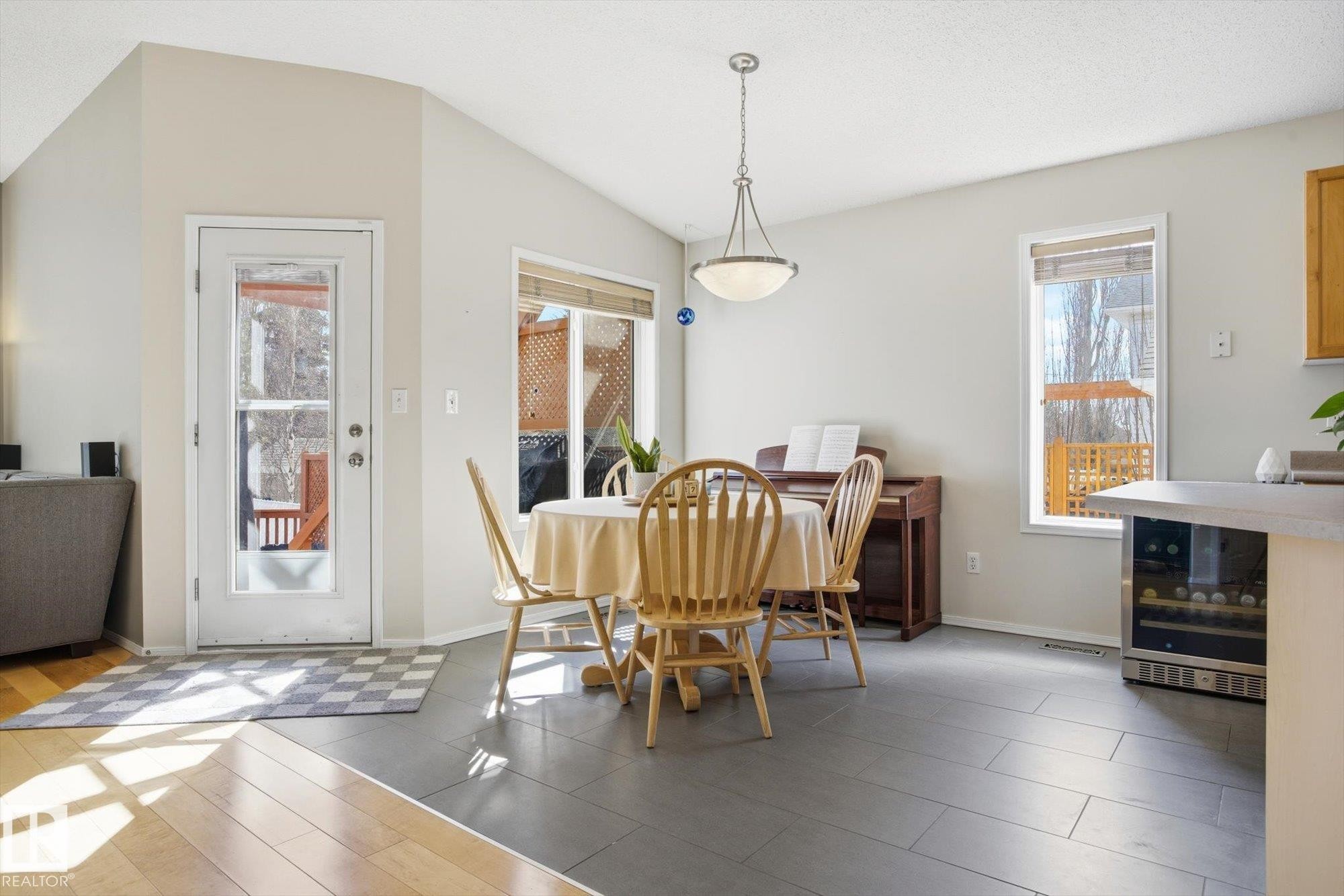 Vaulted ceilings highlight this dining area with grey tile flooring and a full-light exterior door - 2251 Brennan Court, Edmonton, AB - Indoor Photo Showing Dining Room