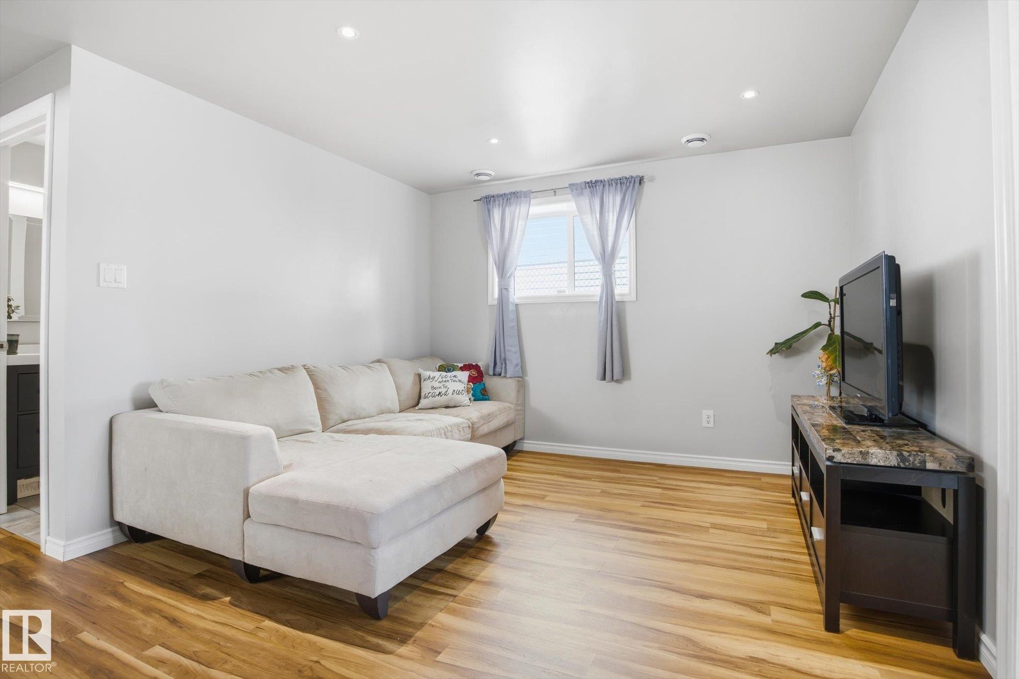 Bright living space featuring wood-finish flooring, recessed lighting, and a white trim package - 2251 Brennan Court, Edmonton, AB - Indoor