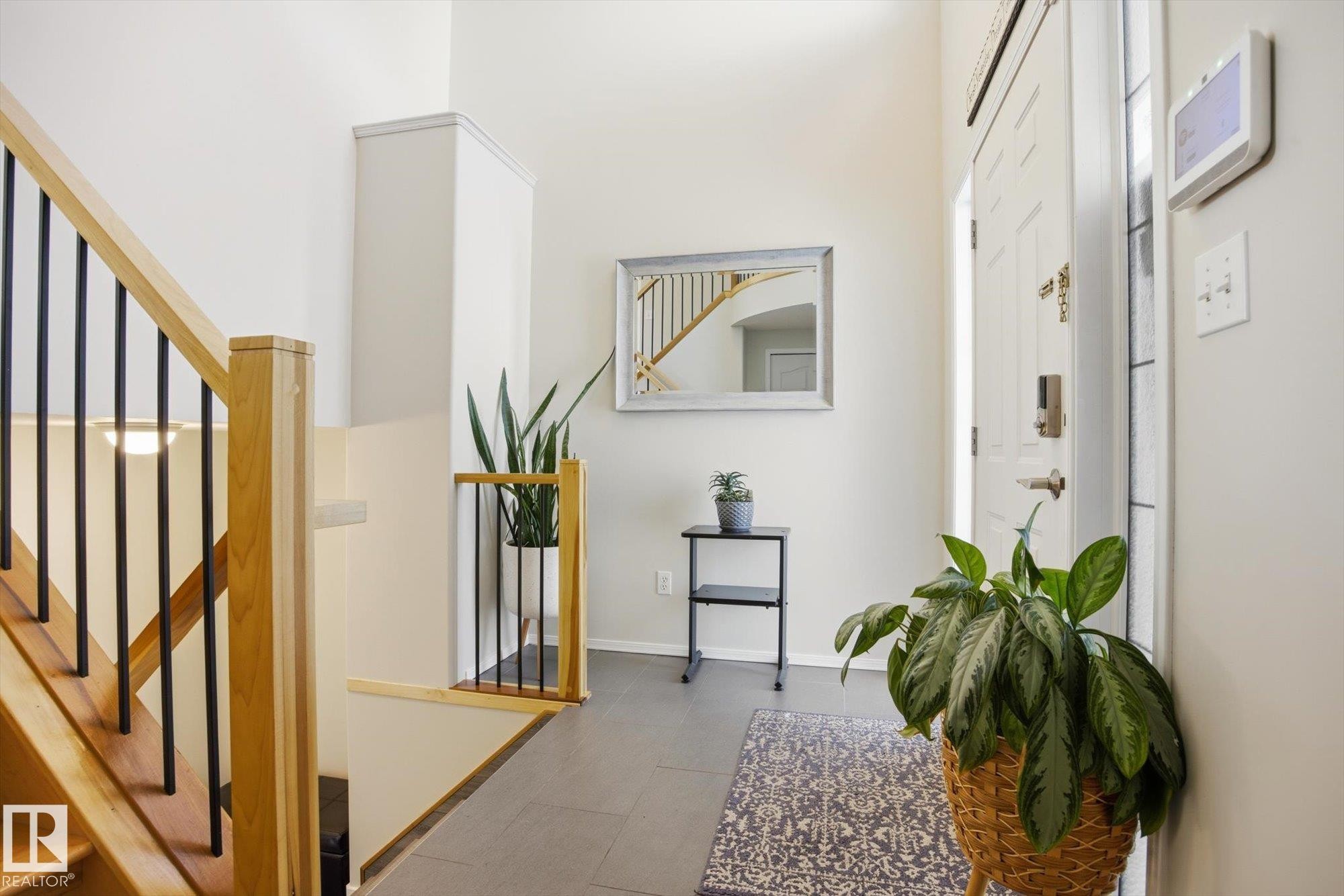 Foyer with wood-finish staircase and black balusters - 2251 Brennan Court, Edmonton, AB - Indoor Photo Showing Other Room