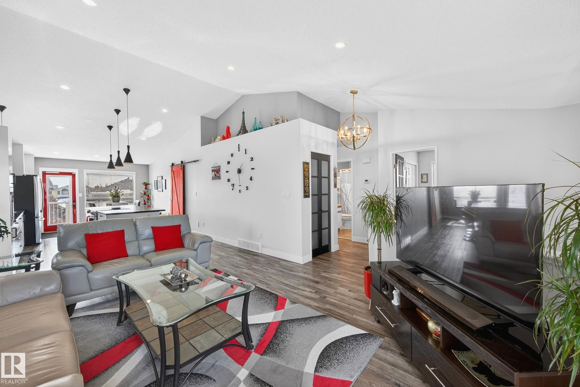 The living area features vaulted ceilings, recessed lighting, and wood-look flooring - 34 Donald Place, St. Albert, AB - Indoor Photo Showing Living Room