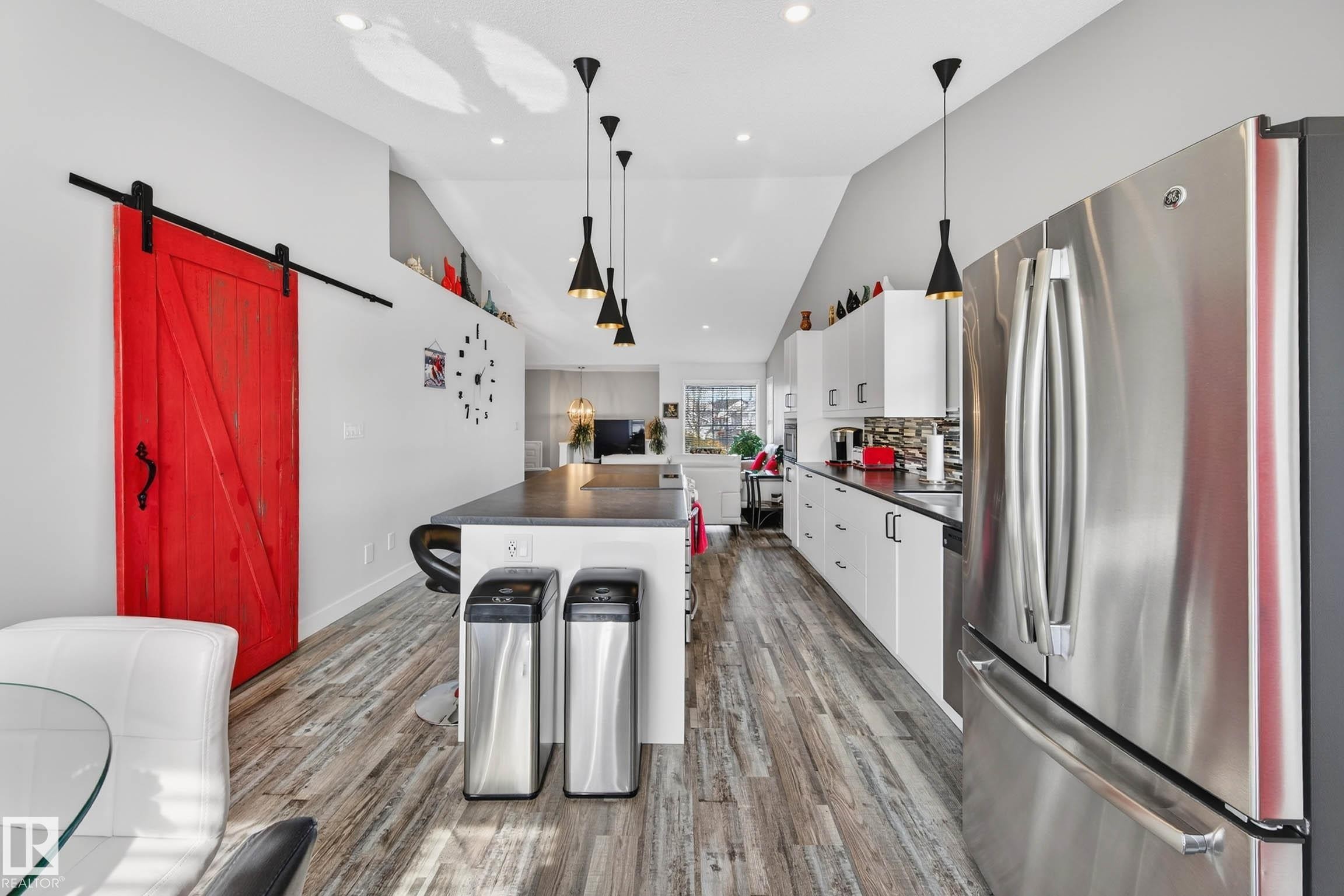 The kitchen features a stainless steel refrigerator, white cabinetry, and dark countertops - 34 Donald Place, St. Albert, AB - Indoor