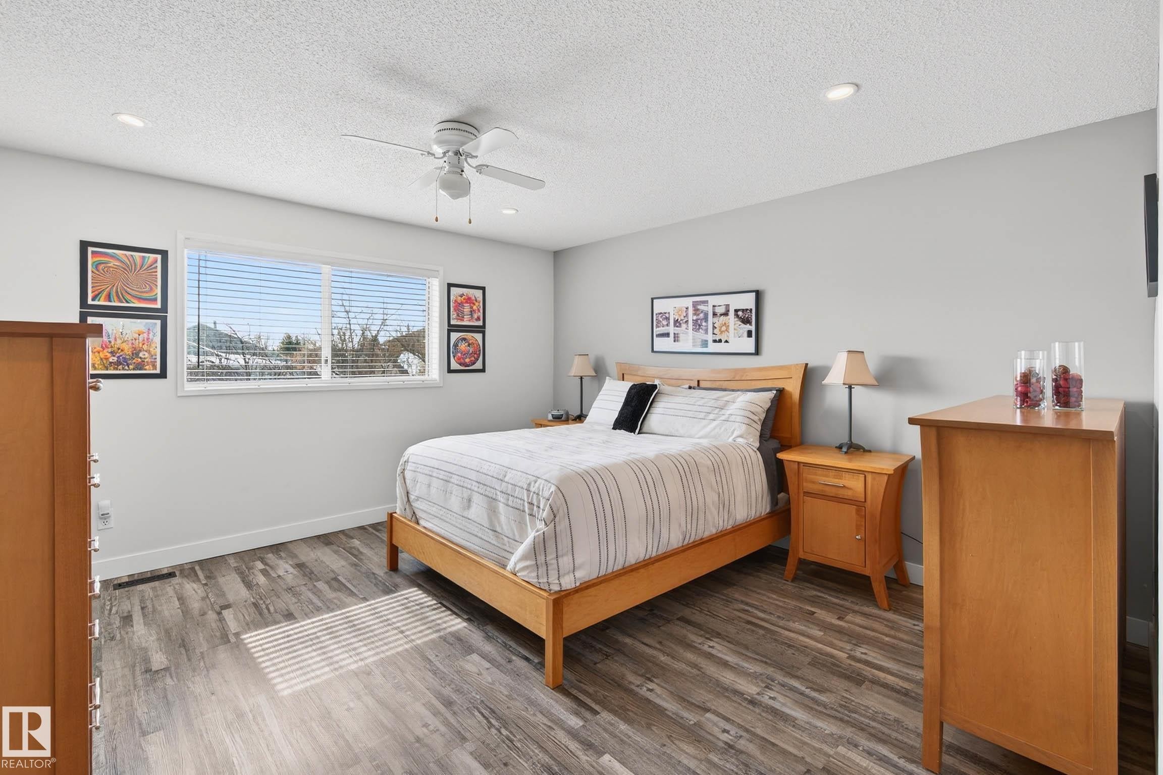 This room features wood-style flooring, a window with horizontal blinds, and a ceiling fan - 34 Donald Place, St. Albert, AB - Indoor Photo Showing Bedroom