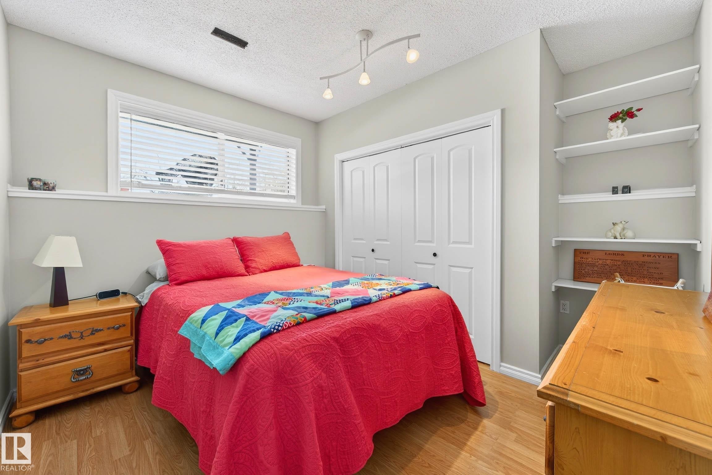 This room features light-colored walls, wood-look flooring, and a window with blinds - 34 Donald Place, St. Albert, AB - Indoor Photo Showing Bedroom