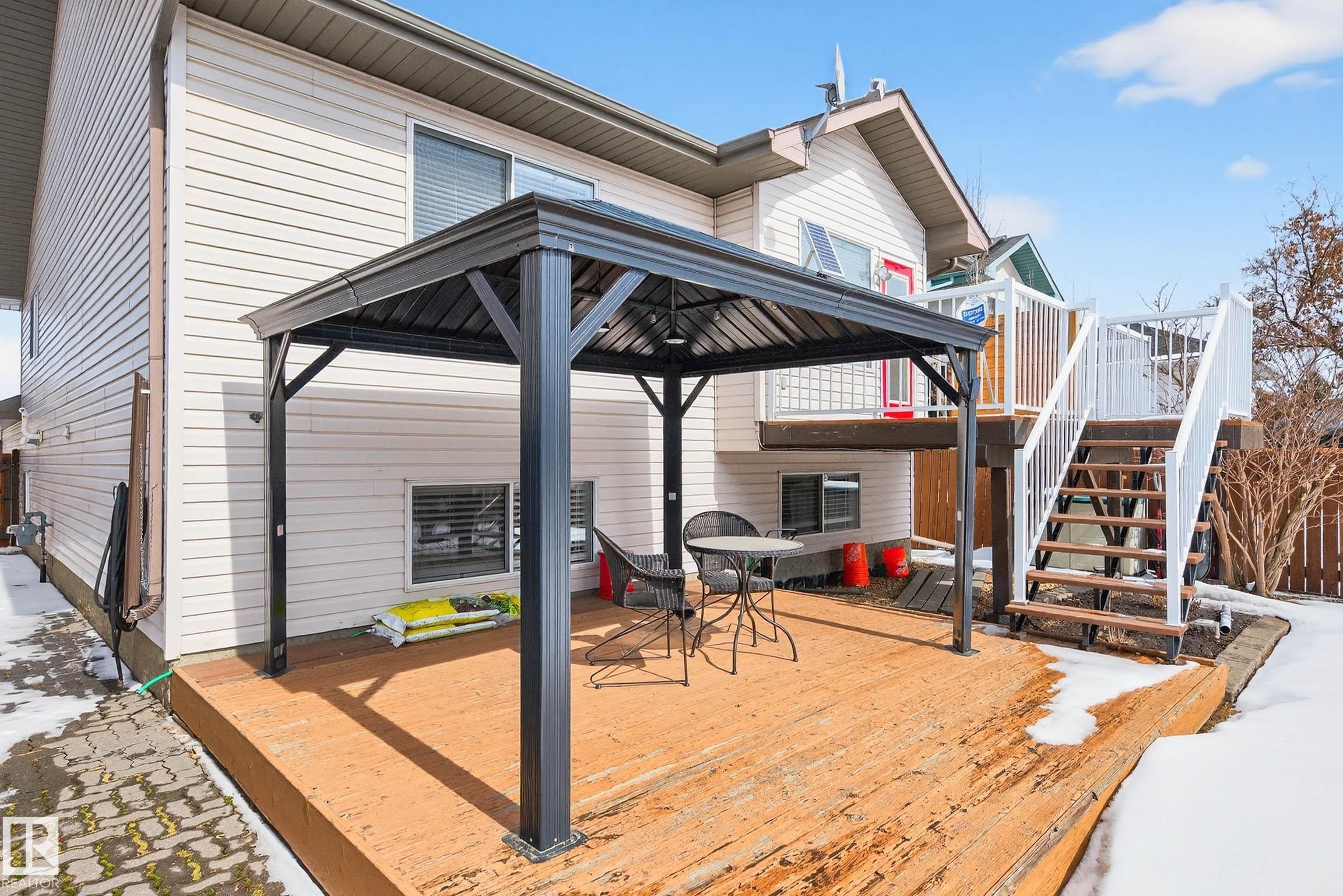 The property features a spacious wooden deck, complete with a dark-colored gazebo providing a shaded seating area - 34 Donald Place, St. Albert, AB - Outdoor With Deck Patio Veranda With Exterior