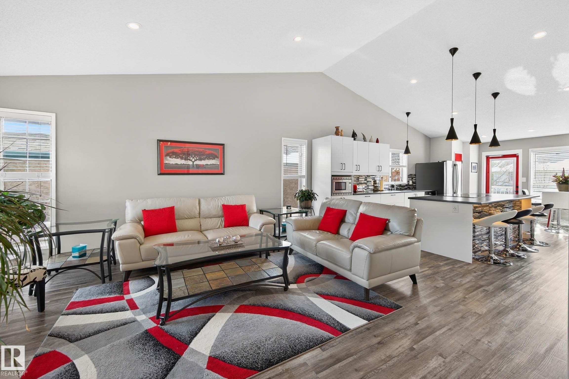 The open concept living area features high vaulted ceilings, recessed lighting, and durable wood-look flooring - 34 Donald Place, St. Albert, AB - Indoor Photo Showing Living Room