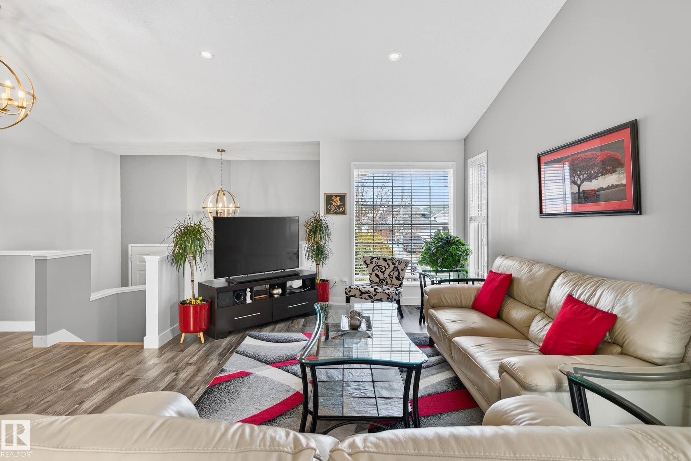 Living area featuring light gray walls, wood-style flooring, and a large window with blinds - 34 Donald Place, St. Albert, AB - Indoor Photo Showing Living Room