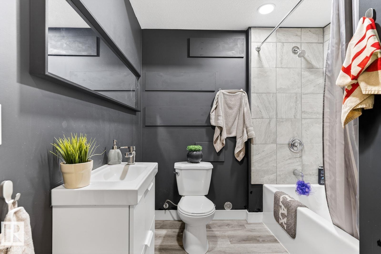 Bathroom featuring a white vanity with integrated sink, chrome faucet, and rectangular mirror - 793 Windermere Wynd, Edmonton, AB - Indoor Photo Showing Bathroom