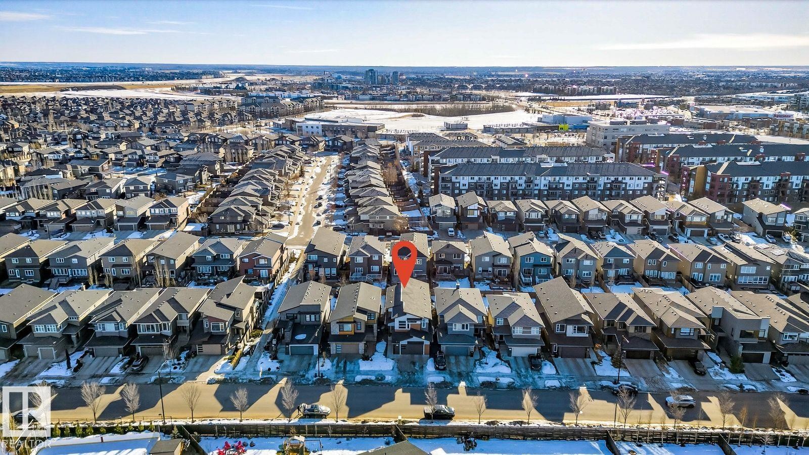 Aerial perspective showcasing a residential neighborhood with a distant cityscape - 793 Windermere Wynd, Edmonton, AB - Outdoor With View