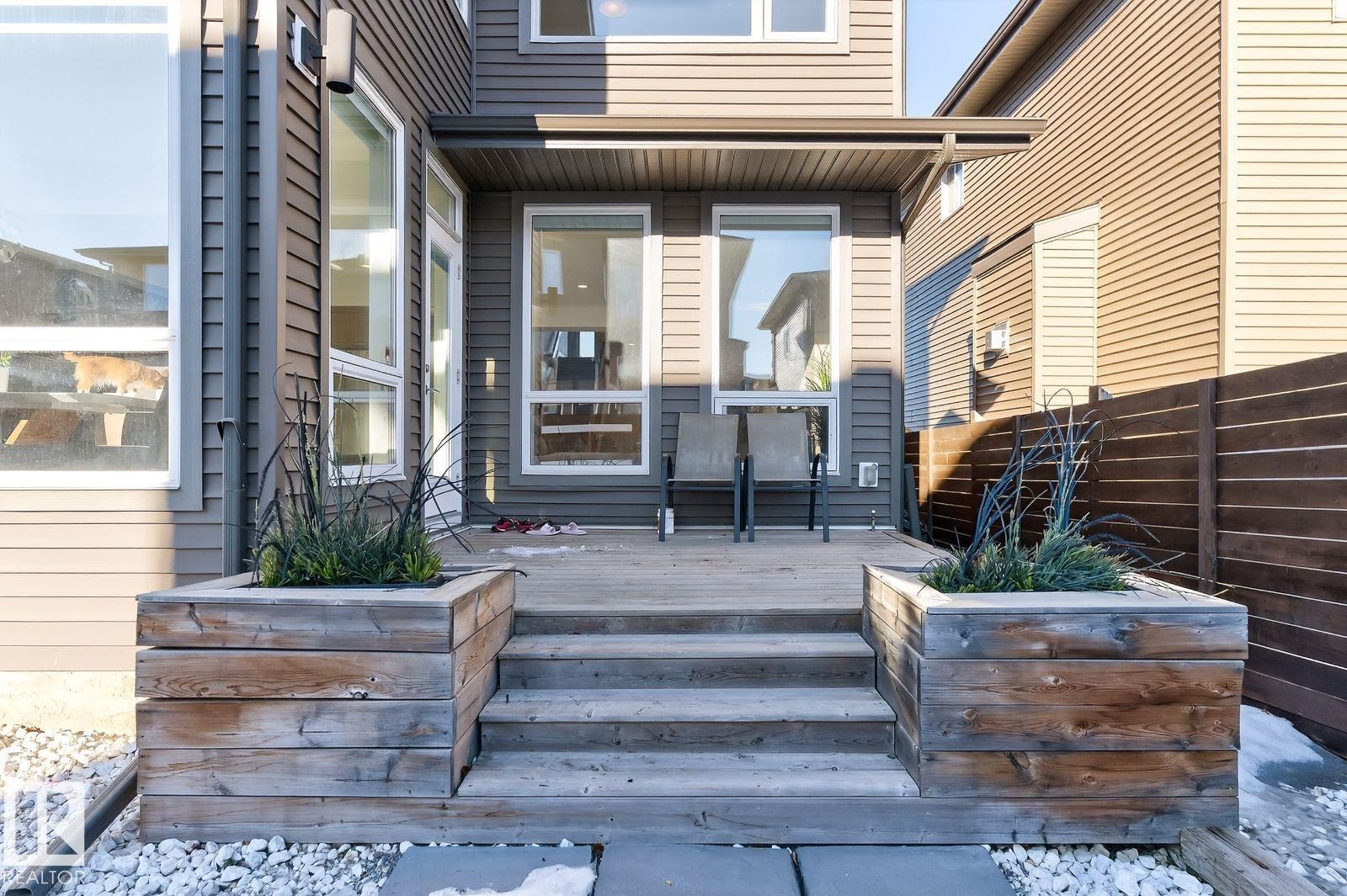 Ground-level patio with wood decking, steps, and integrated planters - 793 Windermere Wynd, Edmonton, AB - Outdoor