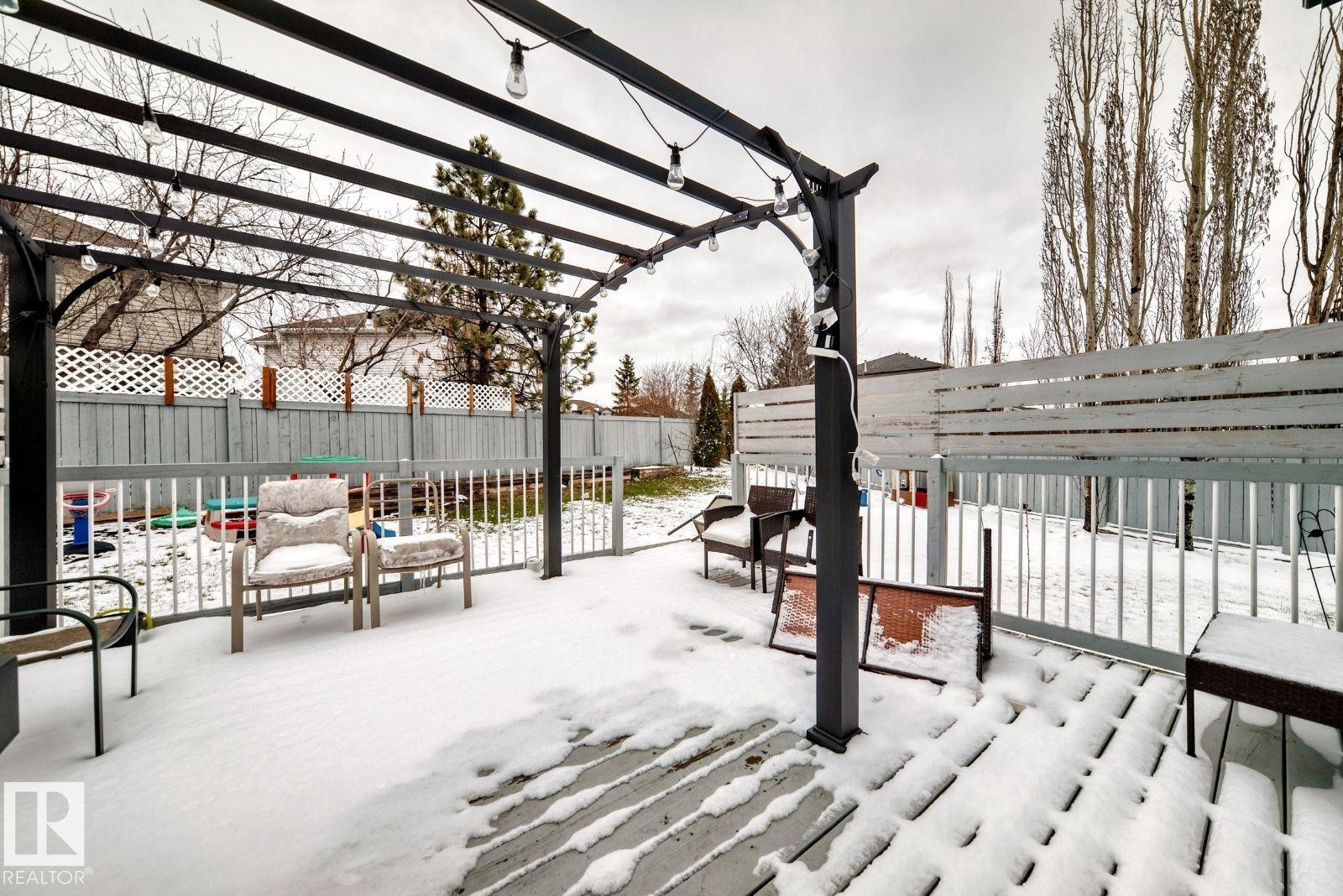 Deck featuring a dark metal pergola with string lighting, light wood-finish decking, and a perimeter railing - 715 Hudson Place, Edmonton, AB - Outdoor