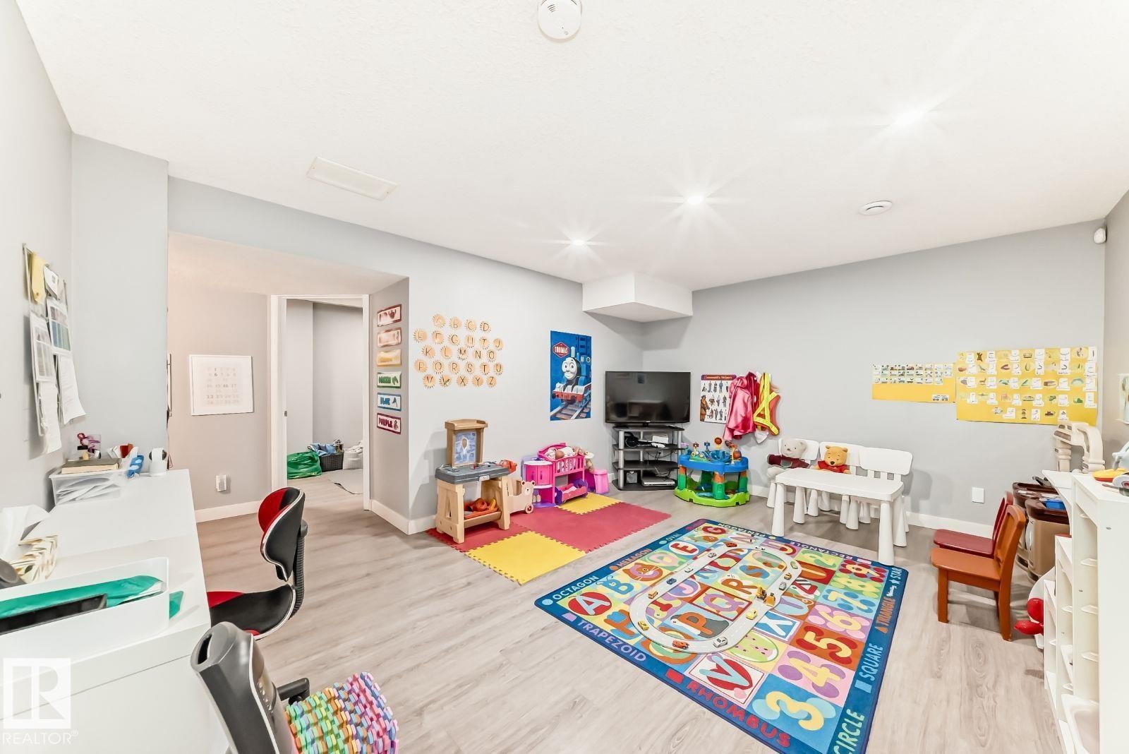 Spacious interior room featuring light-toned walls and wood-finish flooring - 715 Hudson Place, Edmonton, AB - Indoor