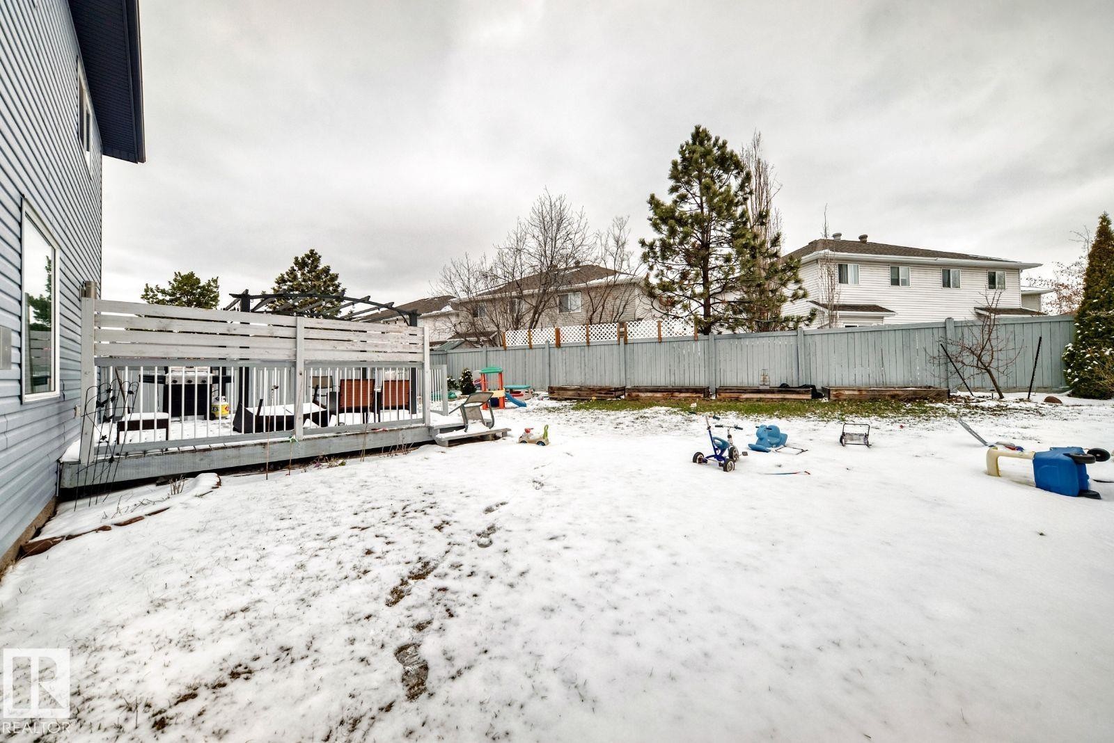 Expansive backyard featuring a wood deck with privacy screening and a perimeter fence - 715 Hudson Place, Edmonton, AB - Outdoor