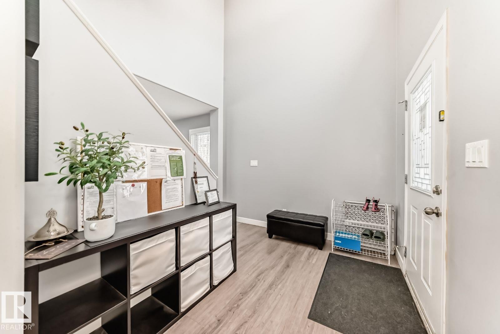 Entryway featuring a decorative front door with transom window, wood-finish flooring, and high ceilings - 715 Hudson Place, Edmonton, AB - Indoor Photo Showing Other Room