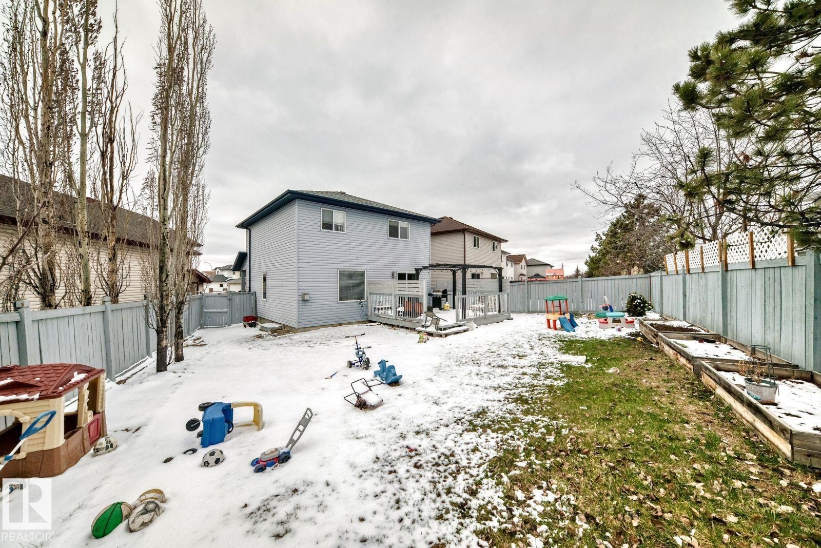 Expansive backyard featuring a multi-level wood deck, raised garden beds, and full perimeter fencing - 715 Hudson Place, Edmonton, AB - Outdoor