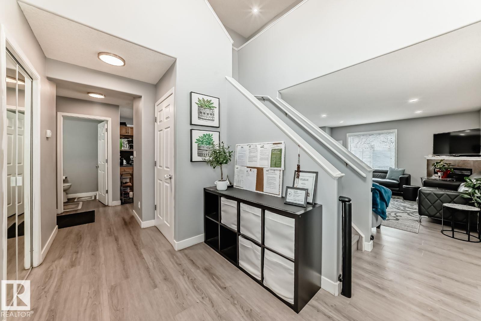 Bright entry hall with wood-finish flooring, white baseboards, and light gray walls - 715 Hudson Place, Edmonton, AB - Indoor Photo Showing Other Room