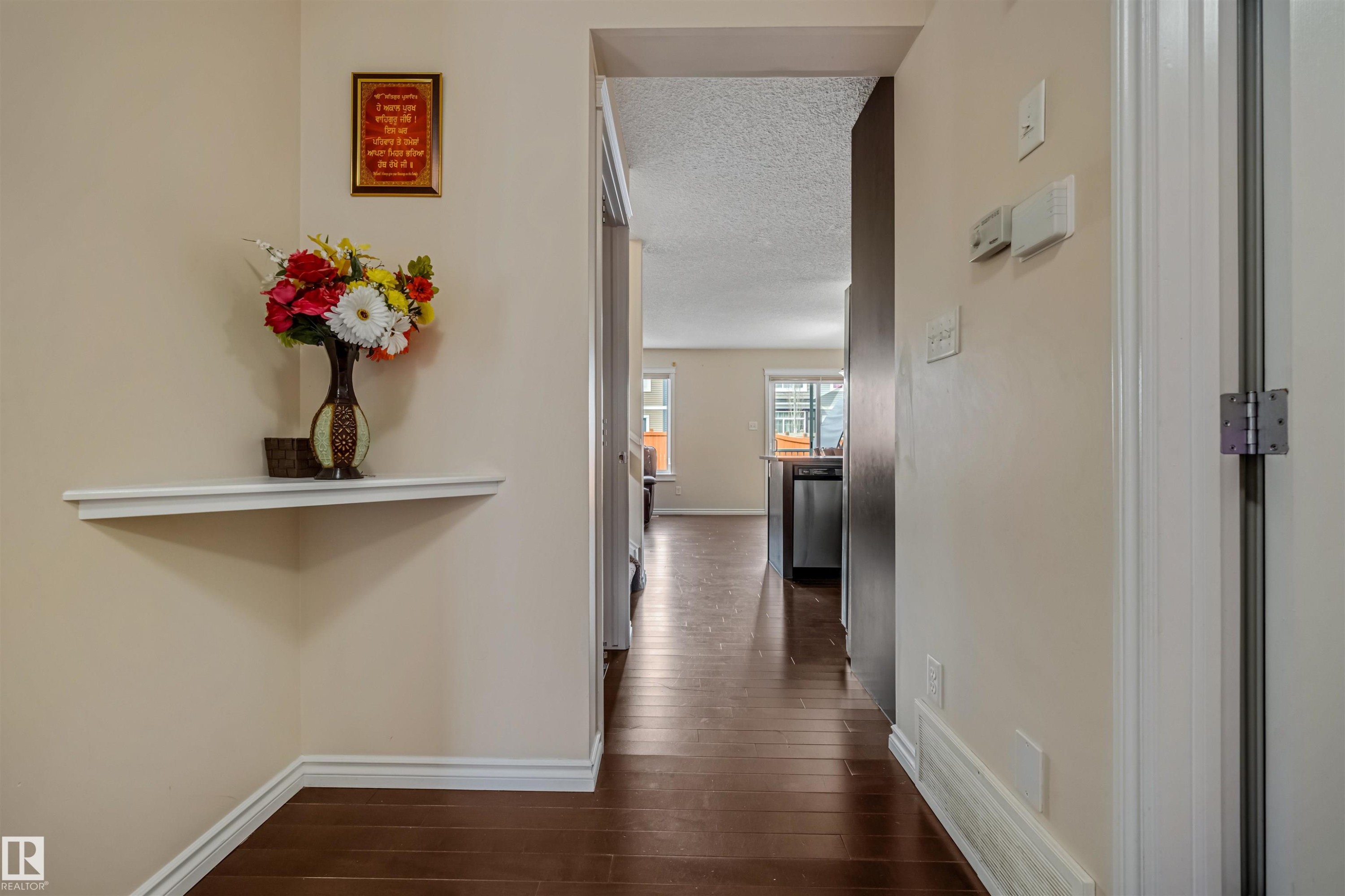 Corridor featuring wood-finish flooring, light-toned wall paint, and white trim - 2314 22 Avenue, Edmonton, AB - Indoor Photo Showing Other Room