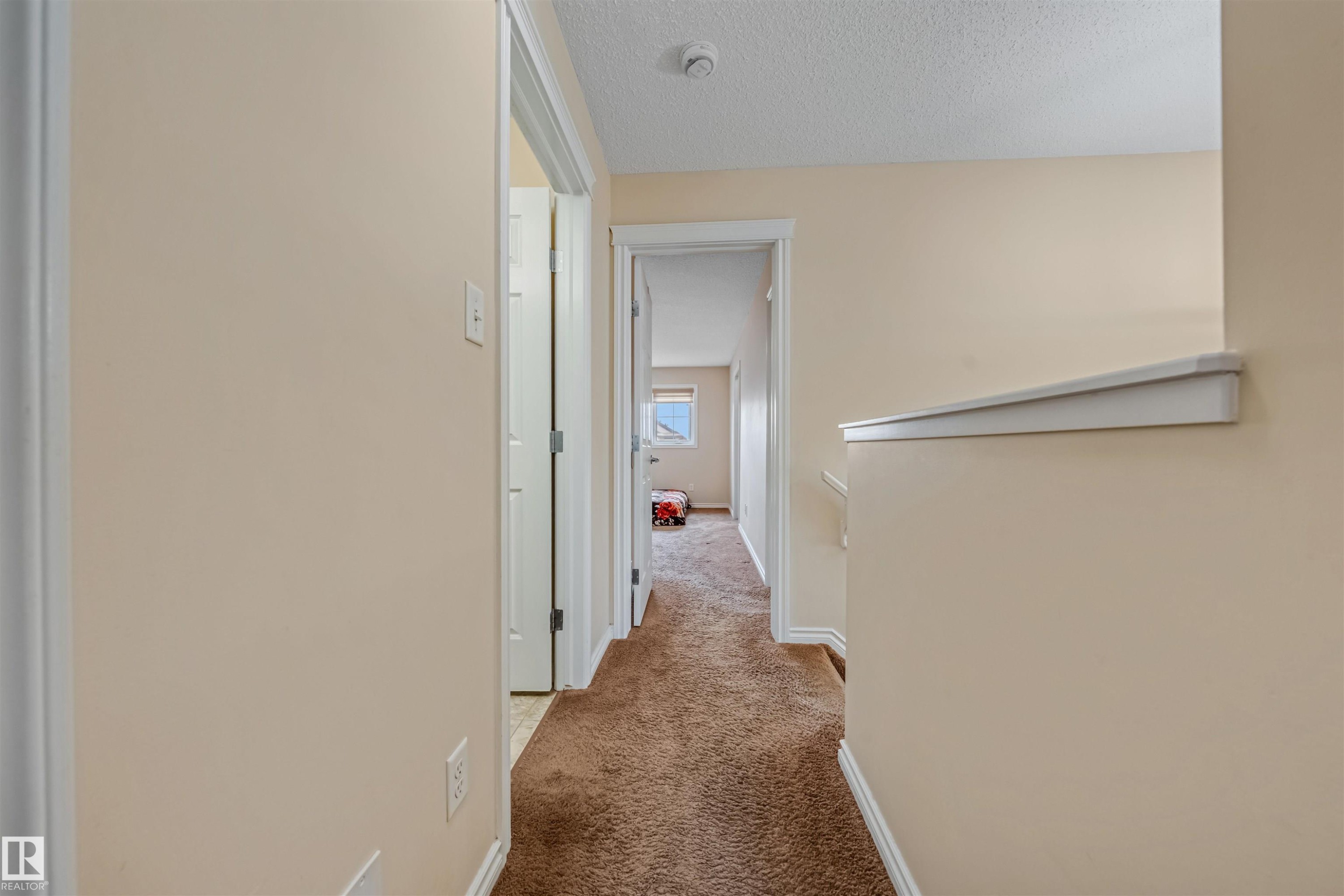 Hallway featuring neutral-toned walls, brown carpet flooring, and white trim - 2314 22 Avenue, Edmonton, AB - Indoor Photo Showing Other Room
