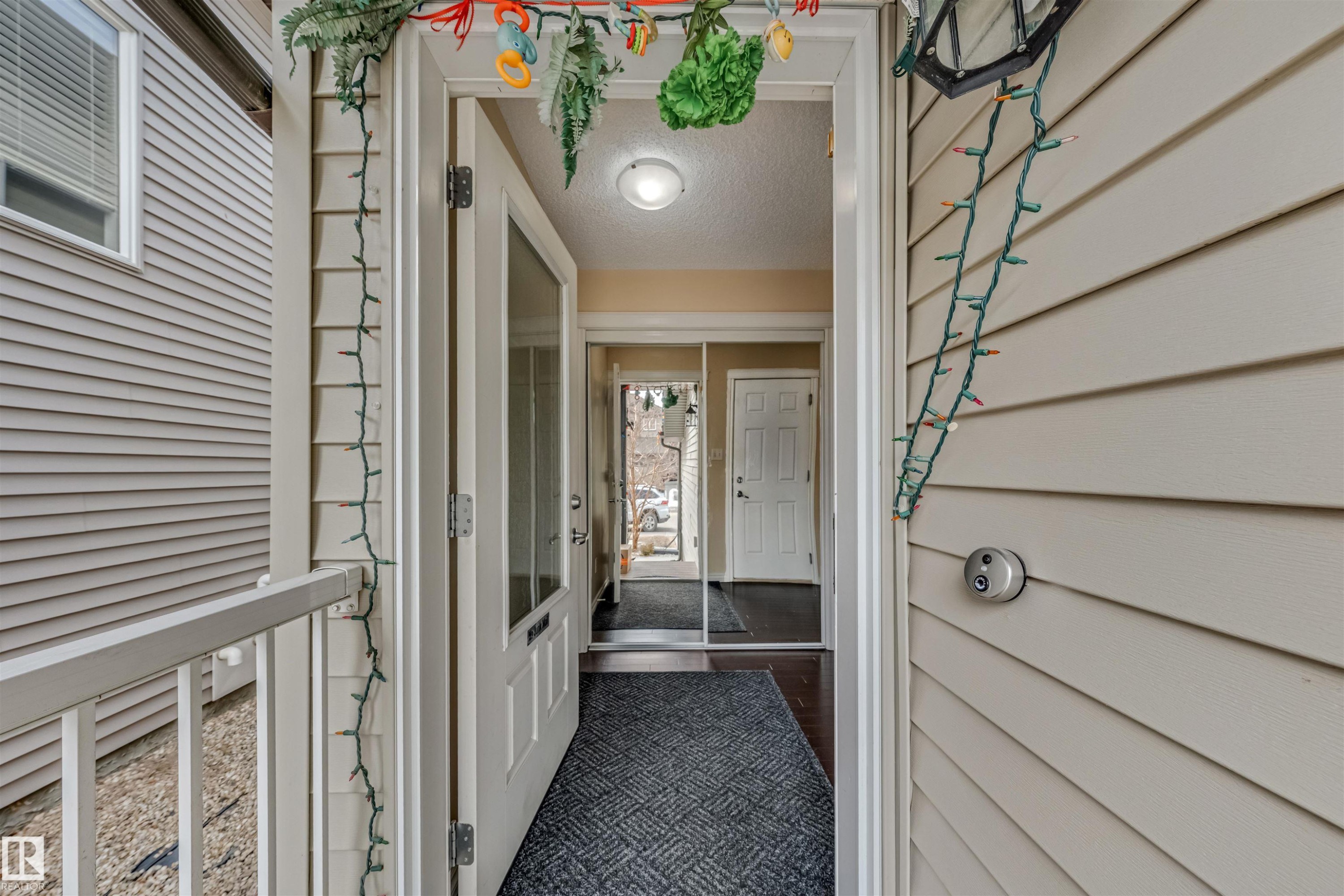 Front entry featuring a light-colored exterior siding, white trim, and a partial glass door - 2314 22 Avenue, Edmonton, AB - Outdoor With Exterior