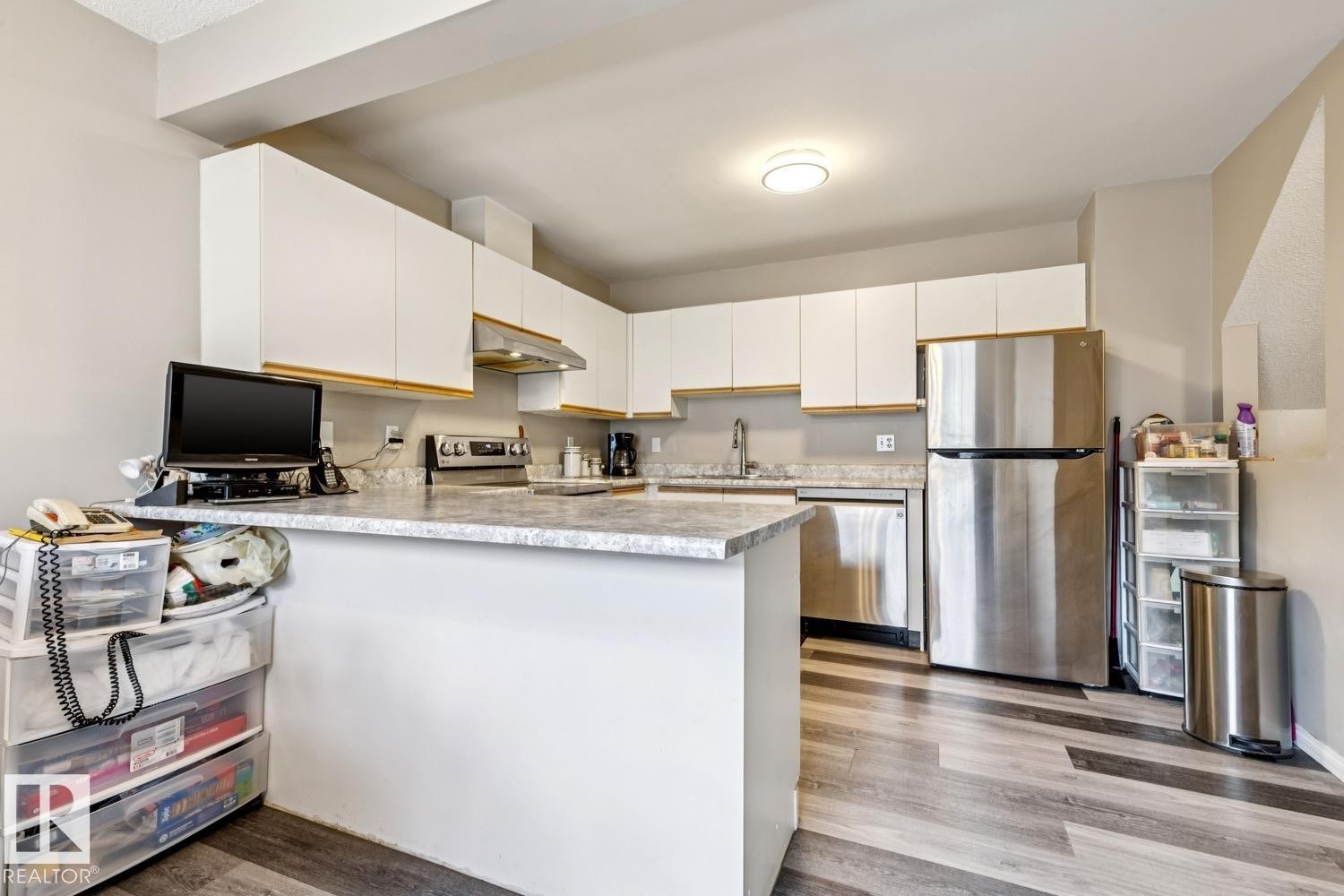 Kitchen featuring wood-finish flooring, white cabinetry, and stainless steel appliances - 40 9520 174 Street, Edmonton, AB - Indoor Photo Showing Kitchen With Stainless Steel Kitchen