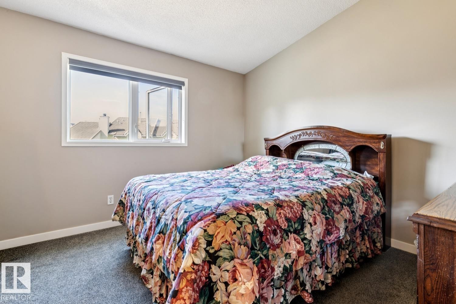 Bedroom featuring a window with white trim, light taupe walls, and dark gray carpet - 40 9520 174 Street, Edmonton, AB - Indoor Photo Showing Bedroom