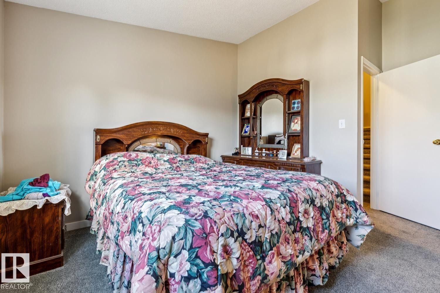 Carpeted bedroom featuring neutral wall tones and a built-in wood headboard - 40 9520 174 Street, Edmonton, AB - Indoor Photo Showing Bedroom