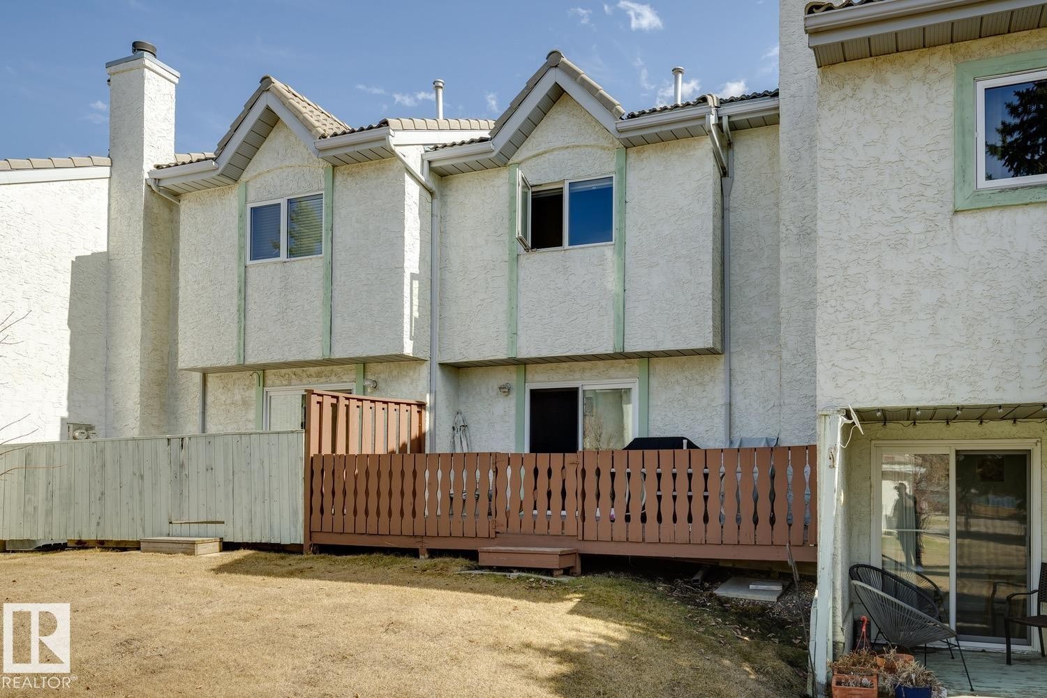 Multi-level stucco exterior with pitched rooflines and a prominent chimney - 40 9520 174 Street, Edmonton, AB - Outdoor