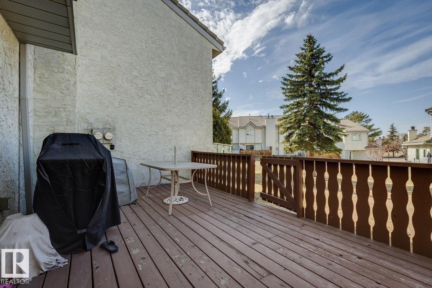 Spacious wooden deck featuring a decorative wood railing and stucco exterior - 40 9520 174 Street, Edmonton, AB - Outdoor With Deck Patio Veranda With Exterior