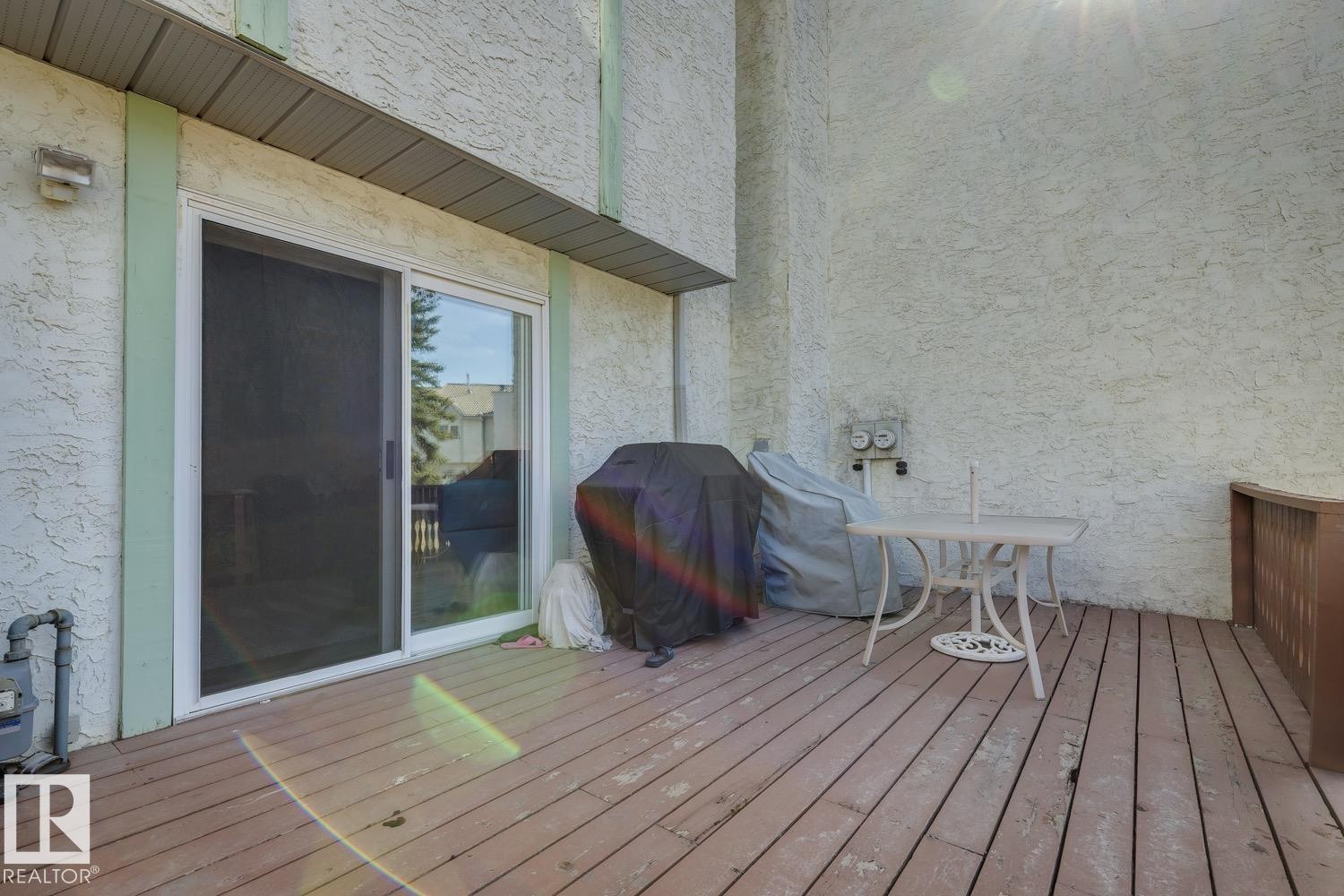 Spacious outdoor deck featuring wood-finish flooring and a white sliding glass door - 40 9520 174 Street, Edmonton, AB - Outdoor With Deck Patio Veranda With Exterior