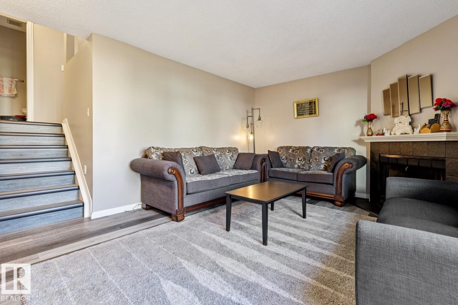 Living area with wood-finish flooring transitioning to carpet - 40 9520 174 Street, Edmonton, AB - Indoor Photo Showing Living Room