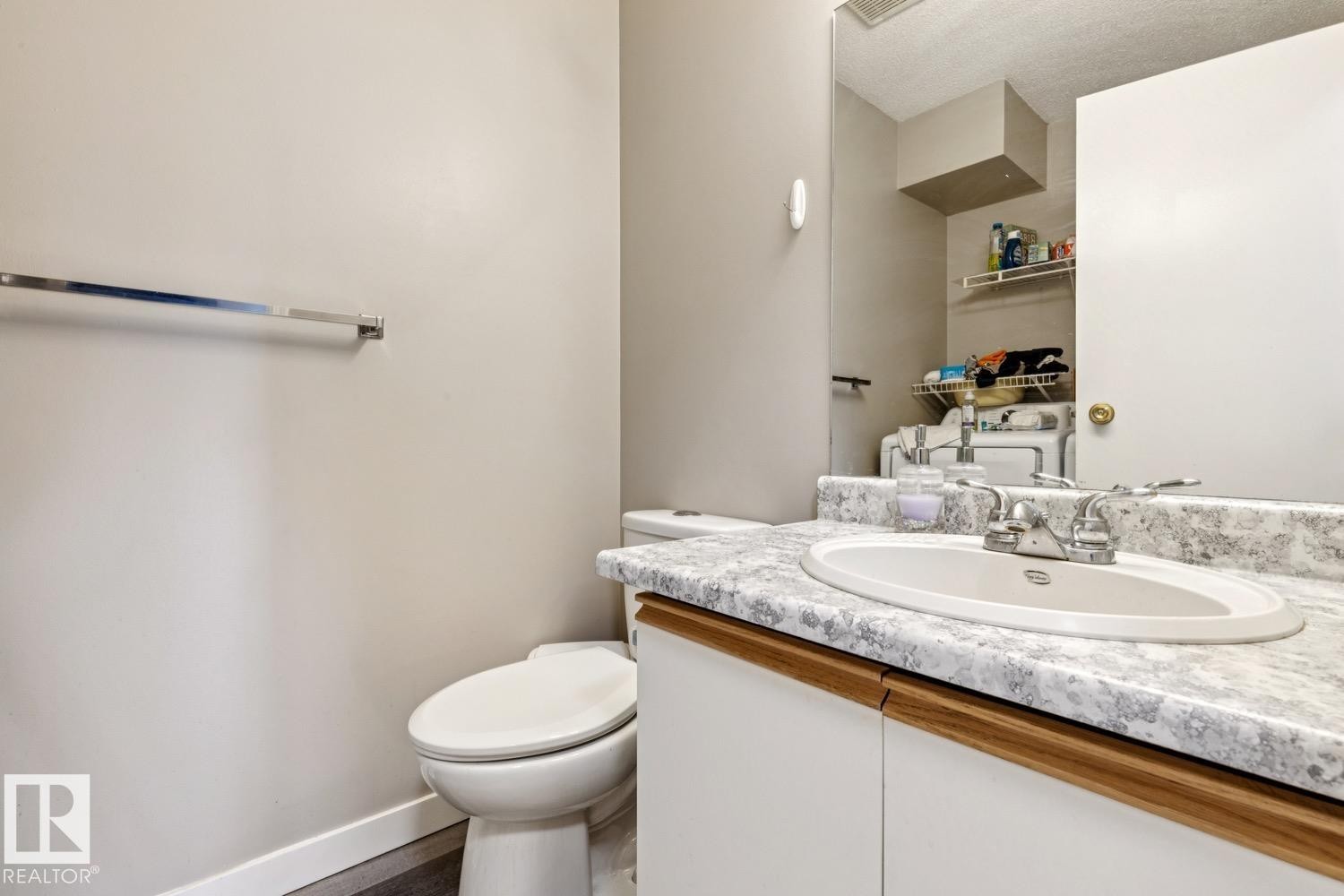 Vanity with integrated sink, patterned countertop, and wood-trim cabinetry - 40 9520 174 Street, Edmonton, AB - Indoor Photo Showing Bathroom