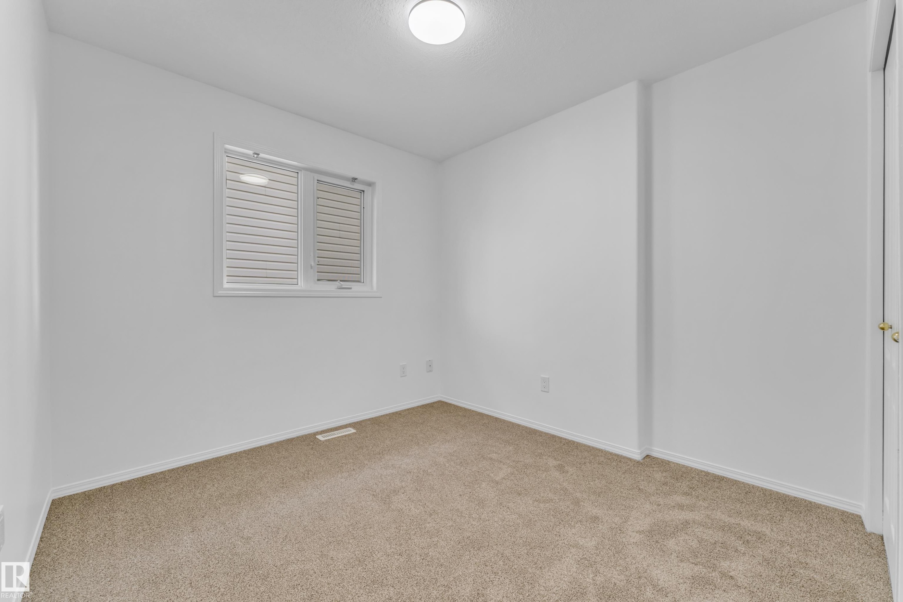 Carpeted room featuring a white interior paint scheme, a window with horizontal blinds, and a flush mount ceiling light fixture - 4103 37A Avenue, Edmonton, AB - Indoor Photo Showing Other Room