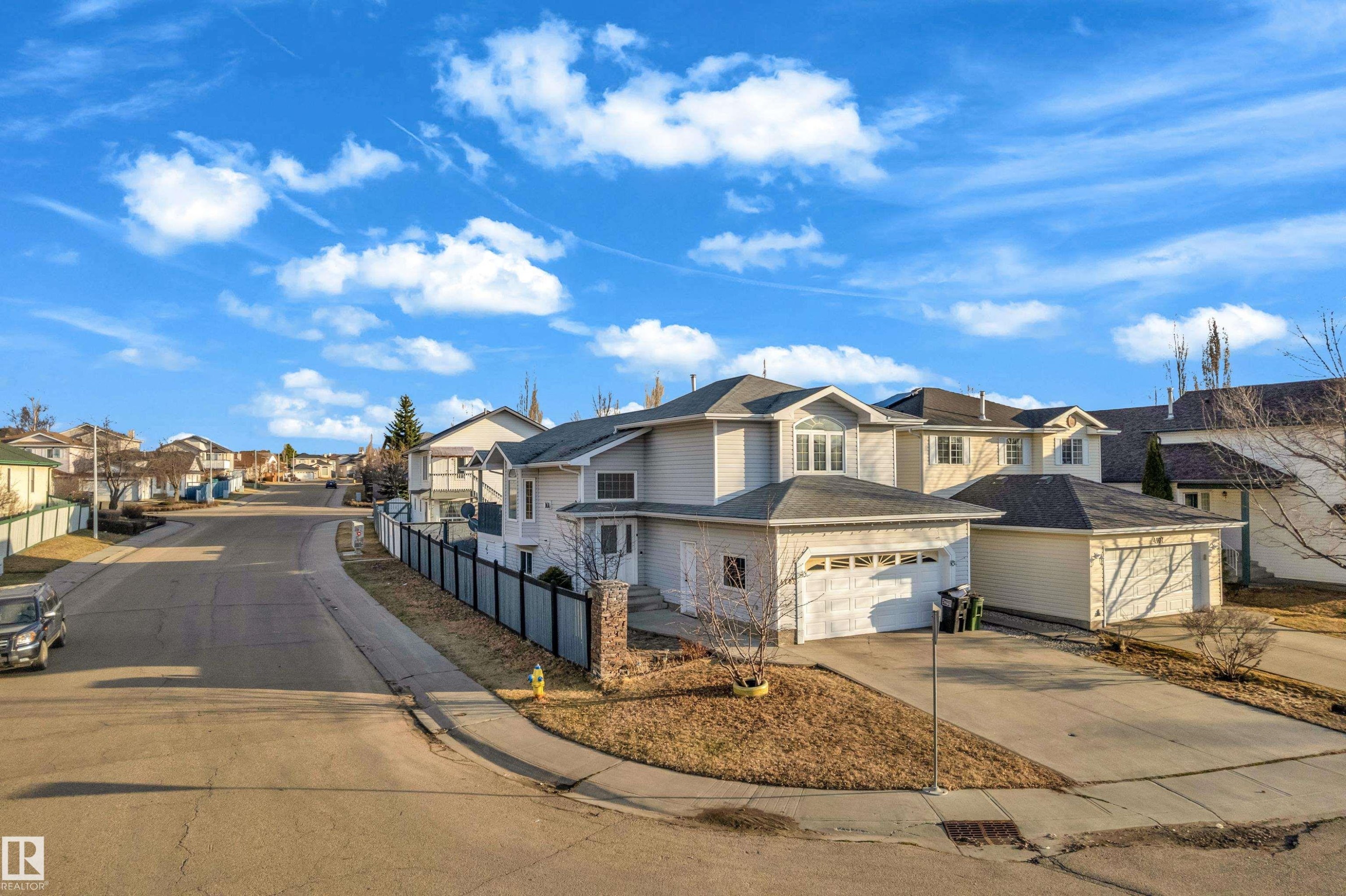 Modern multi-story property featuring light-colored siding, a prominent two-car garage with white doors, and a concrete driveway - 4103 37A Avenue, Edmonton, AB - Outdoor