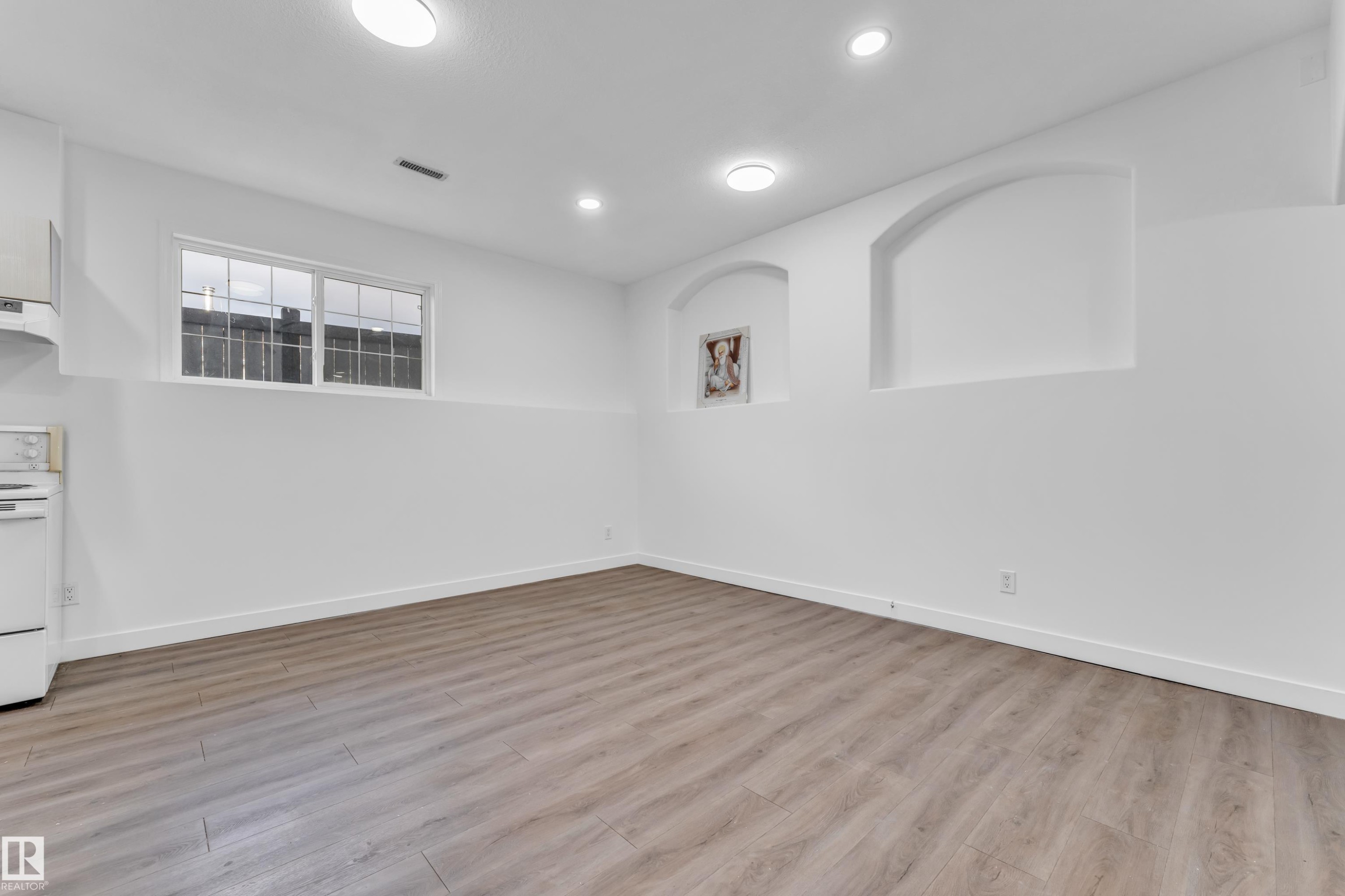 Open-concept living space featuring wood-finish flooring, recessed lighting, and a window with horizontal panes - 4103 37A Avenue, Edmonton, AB - Indoor