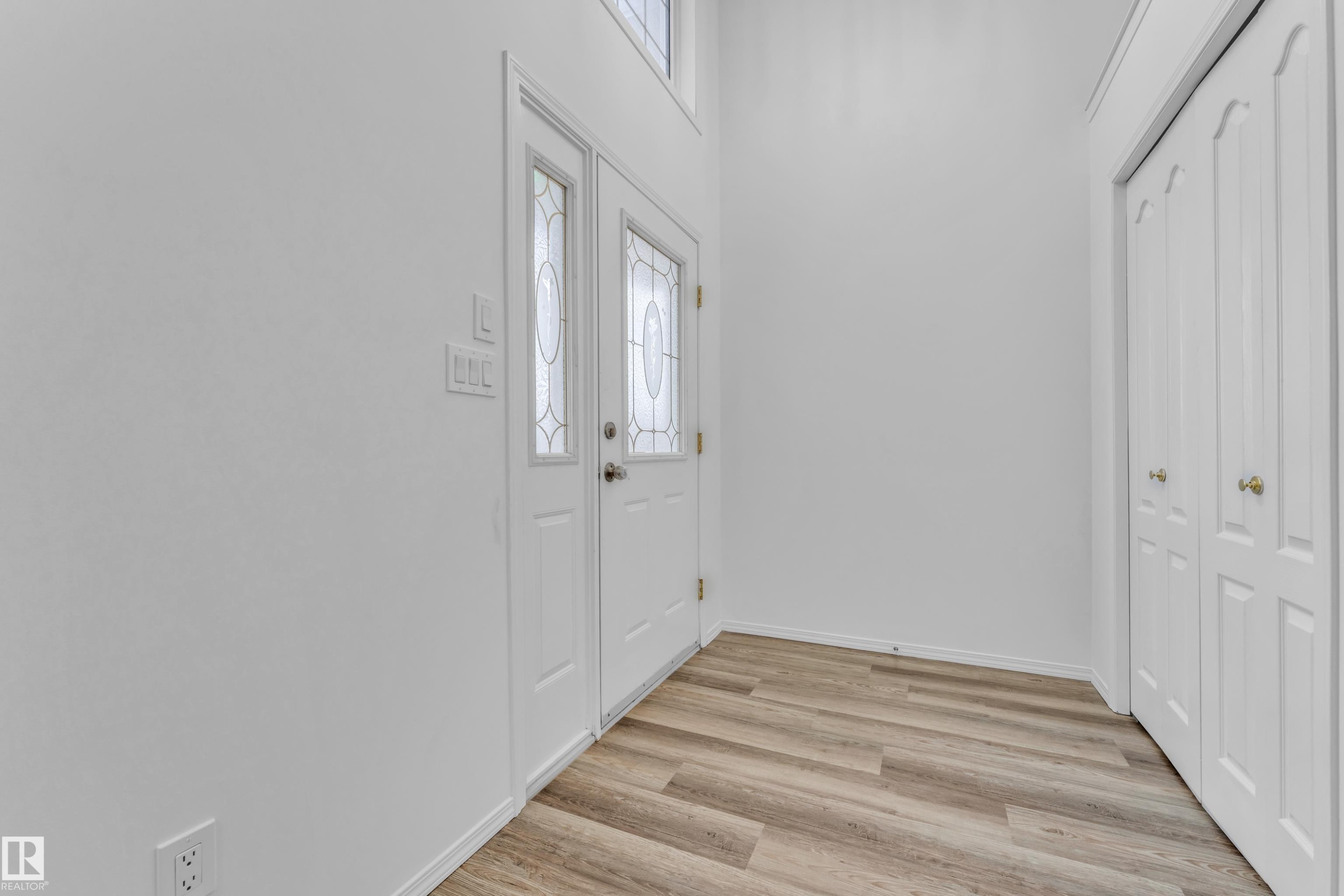 Entryway featuring double doors with decorative glass panels, wood-finish flooring, and a bifold closet - 4103 37A Avenue, Edmonton, AB - Indoor Photo Showing Other Room