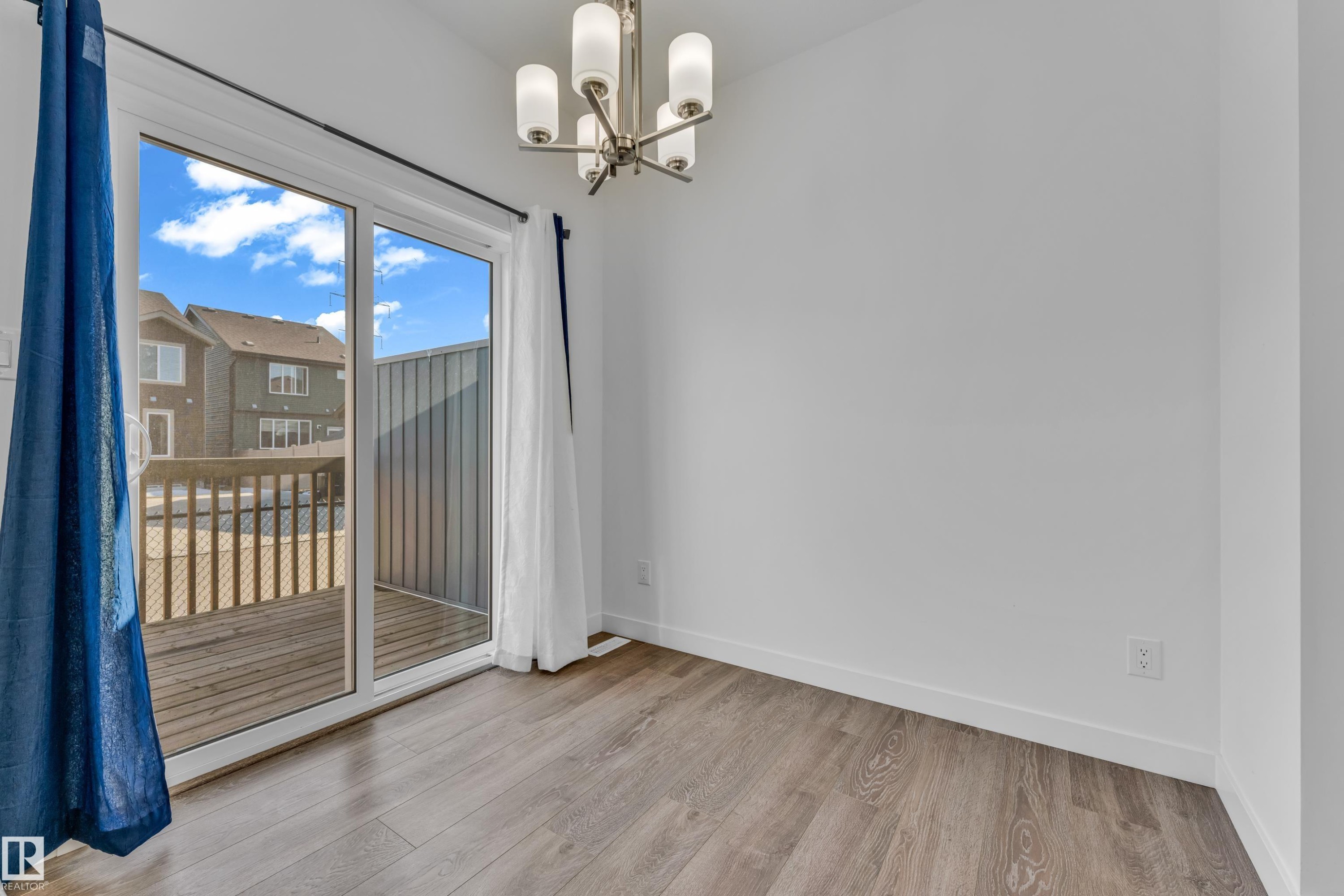 Sliding glass door opening to a wooden deck - 41 603 Orchards Boulevard, Edmonton, AB - Indoor Photo Showing Other Room