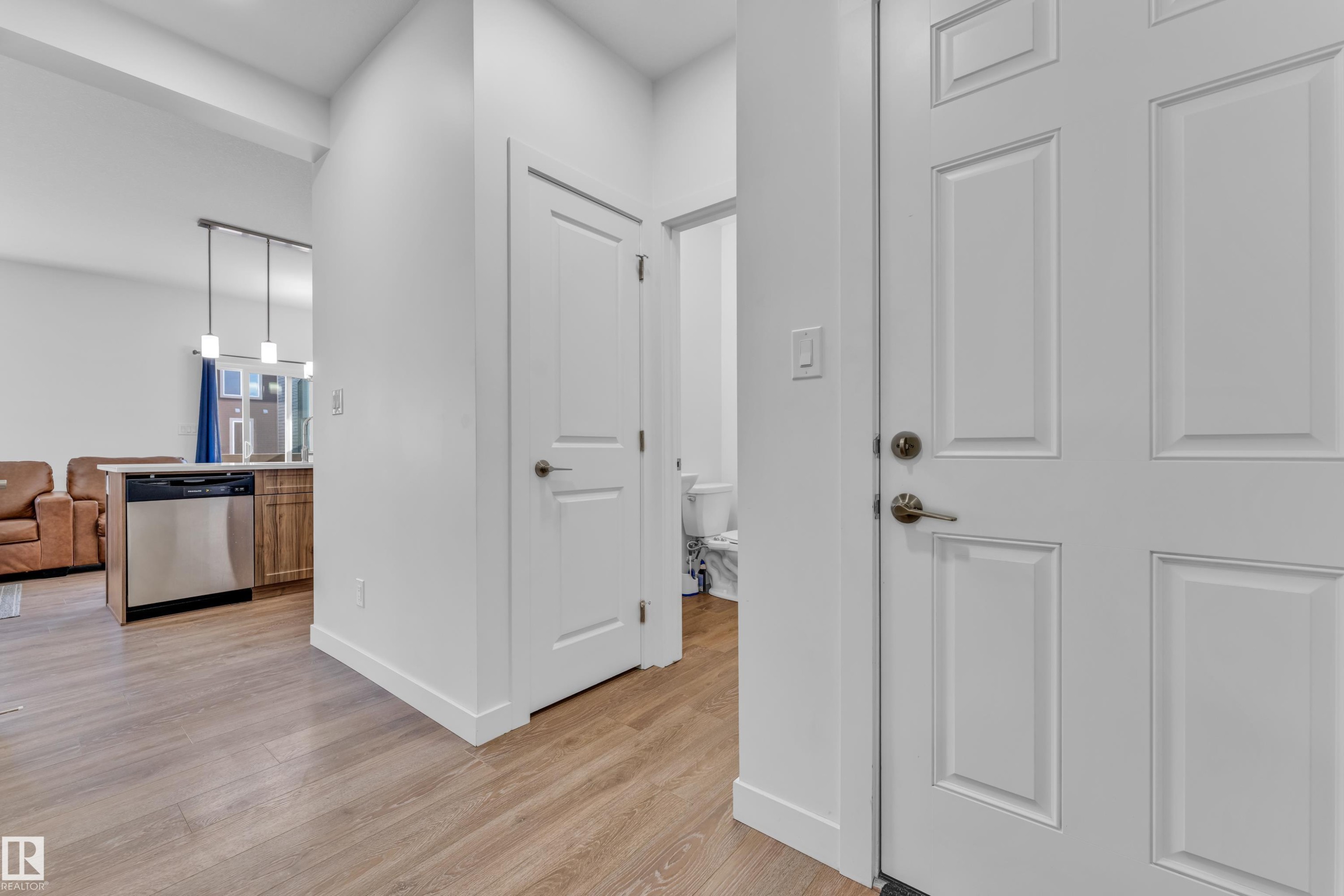 Entryway featuring wood-finish flooring, white paneled doors, and contemporary white walls - 41 603 Orchards Boulevard, Edmonton, AB - Indoor Photo Showing Other Room