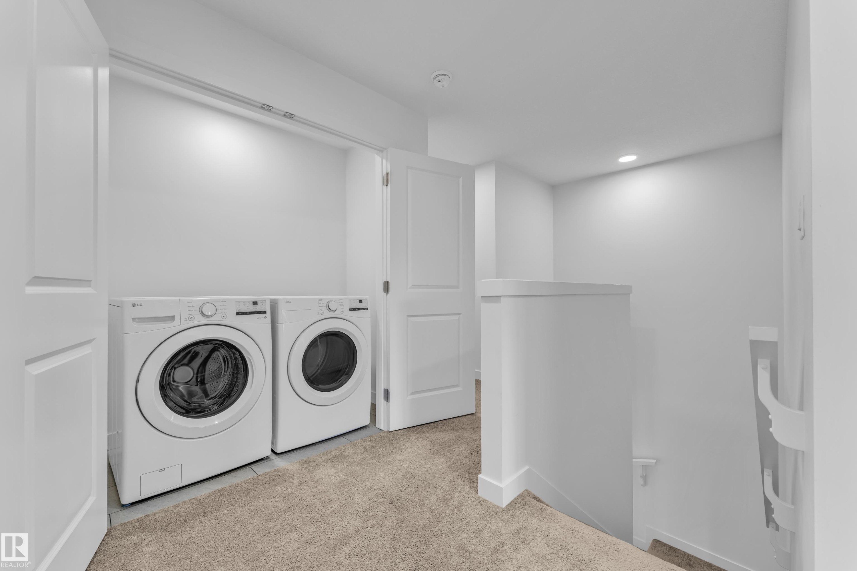 Dedicated laundry area featuring front-loading appliances, neutral wall colors, and recessed lighting - 41 603 Orchards Boulevard, Edmonton, AB - Indoor Photo Showing Laundry Room