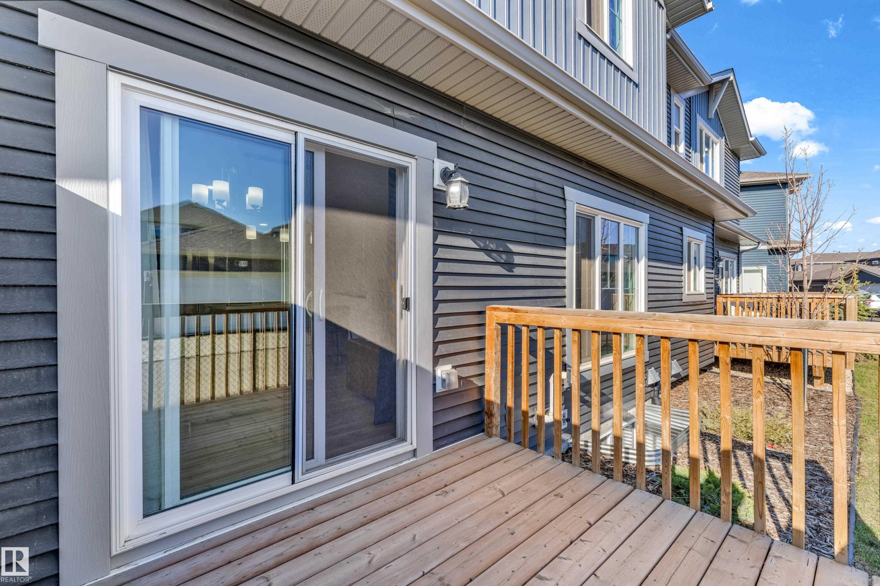 Exterior deck with natural wood railing and wood-finish flooring - 41 603 Orchards Boulevard, Edmonton, AB - Outdoor With Deck Patio Veranda With Exterior