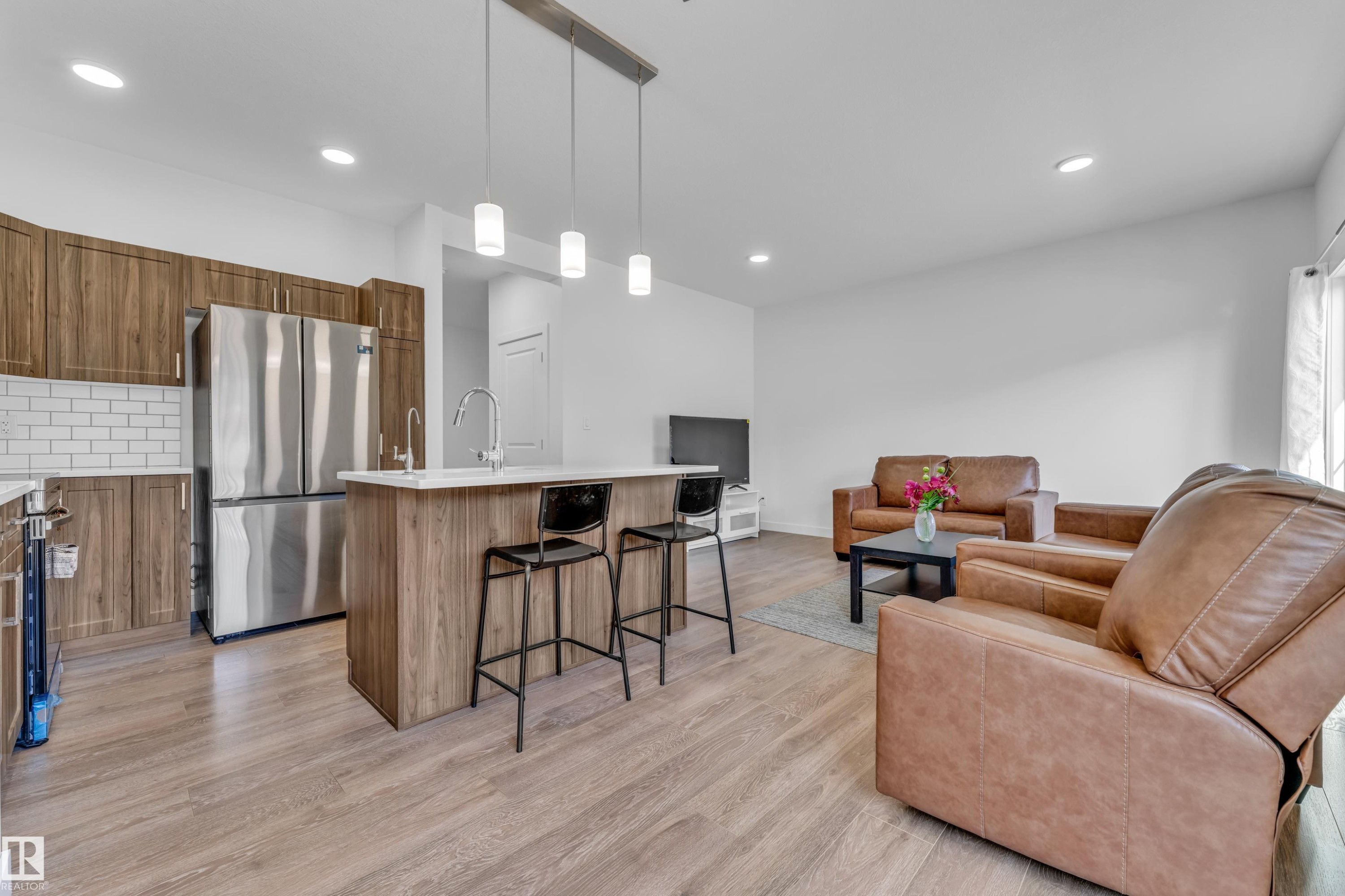 Open-concept living area with wood-finish flooring throughout - 41 603 Orchards Boulevard, Edmonton, AB - Indoor Photo Showing Kitchen