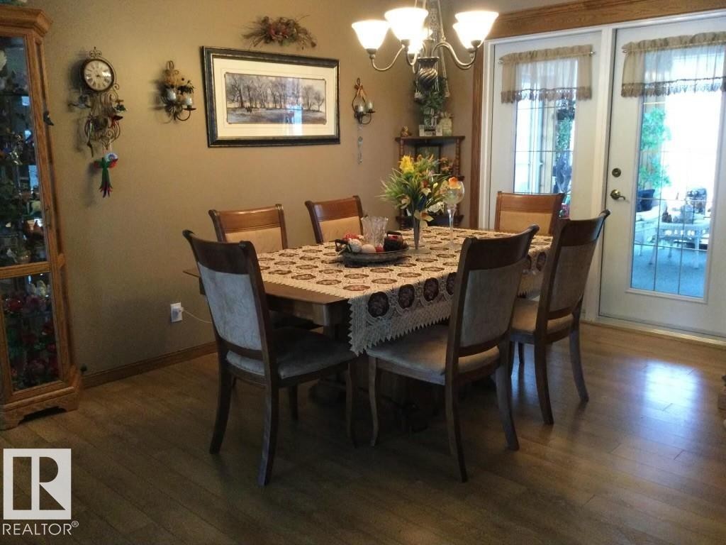 Dining area featuring wood-finish flooring, a chandelier, and double French doors with transom windows - 123064 Hwy 45, Rural Two Hills County, AB