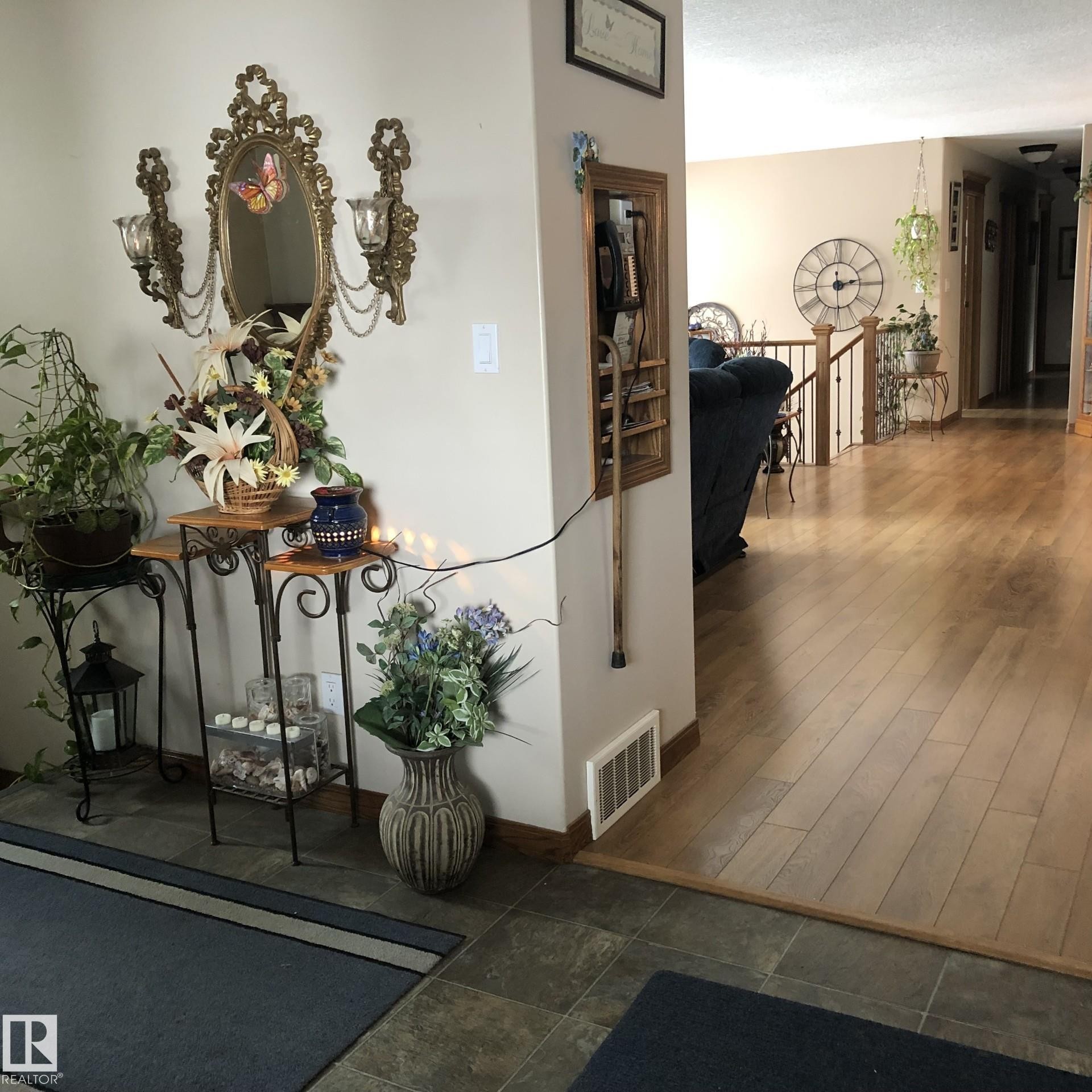 Entryway featuring large format tile flooring transitioning to wood-finish flooring - 123064 Hwy 45, Rural Two Hills County, AB