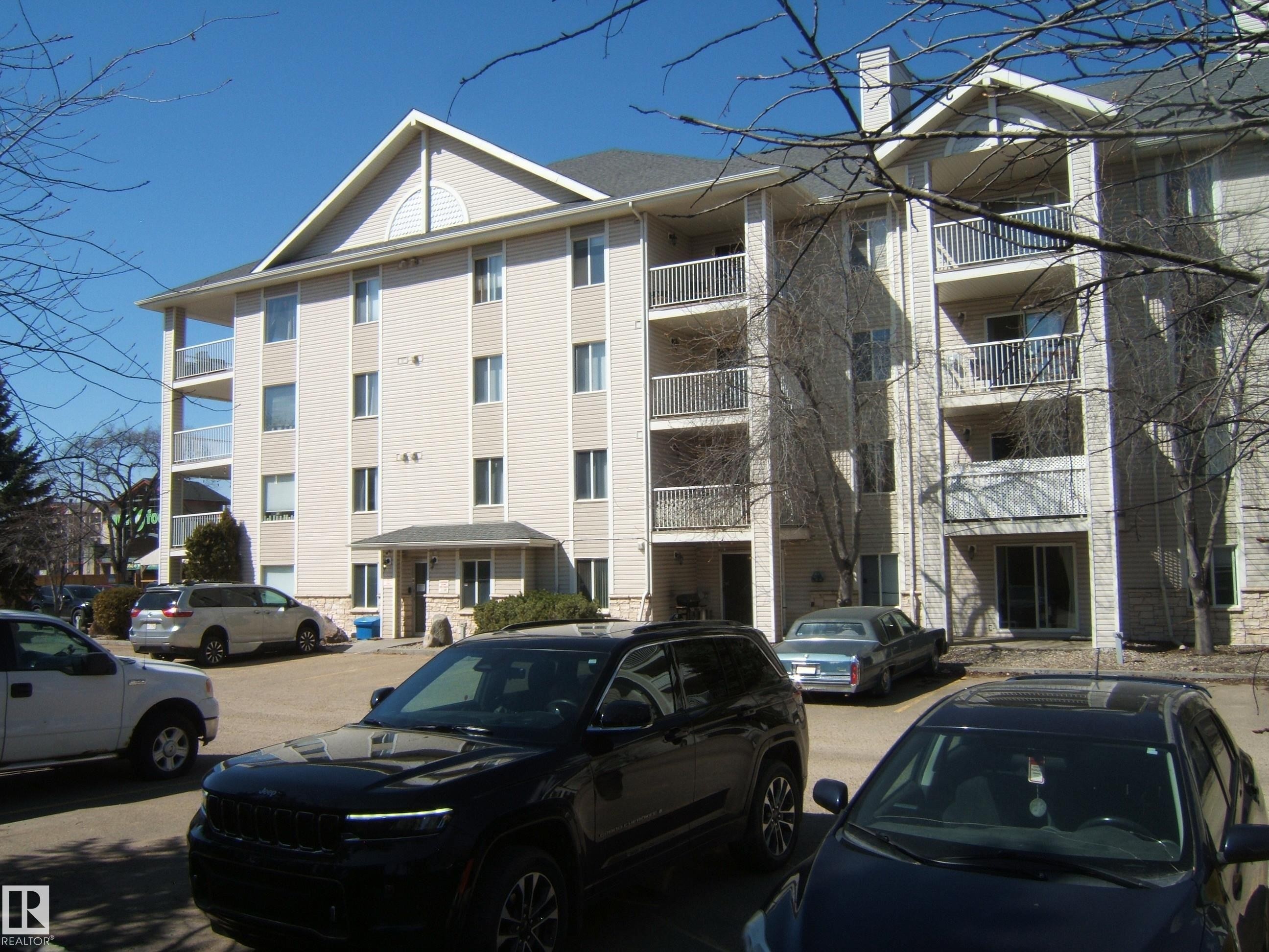 Multi-story building featuring light-colored siding and multiple private balconies with white railings - 105 11214 80 Street, Edmonton, AB - Outdoor