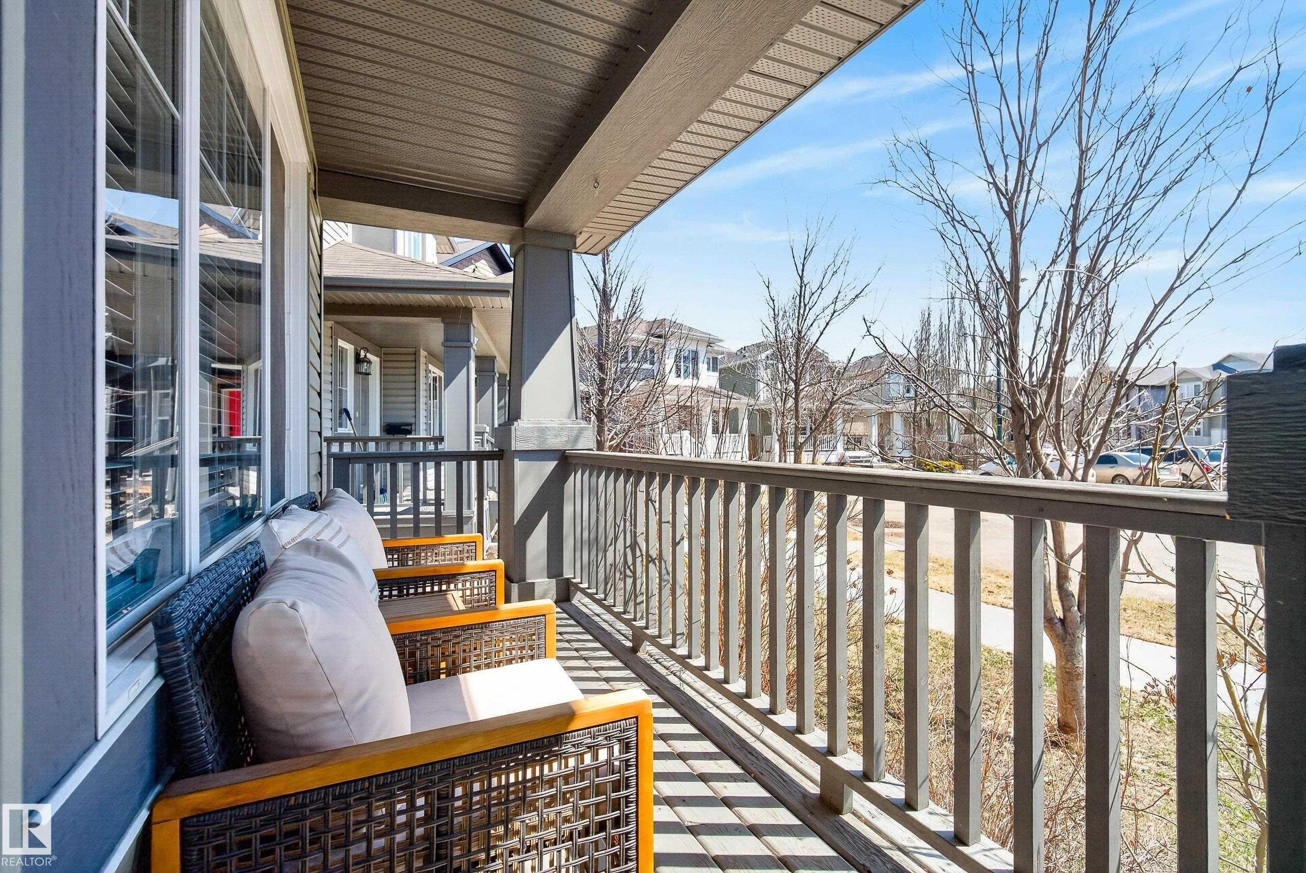 Covered front porch featuring a dark gray siding exterior, white-framed windows, and a matching dark gray railing - 1148 35 Avenue, Edmonton, AB - Outdoor With Exterior