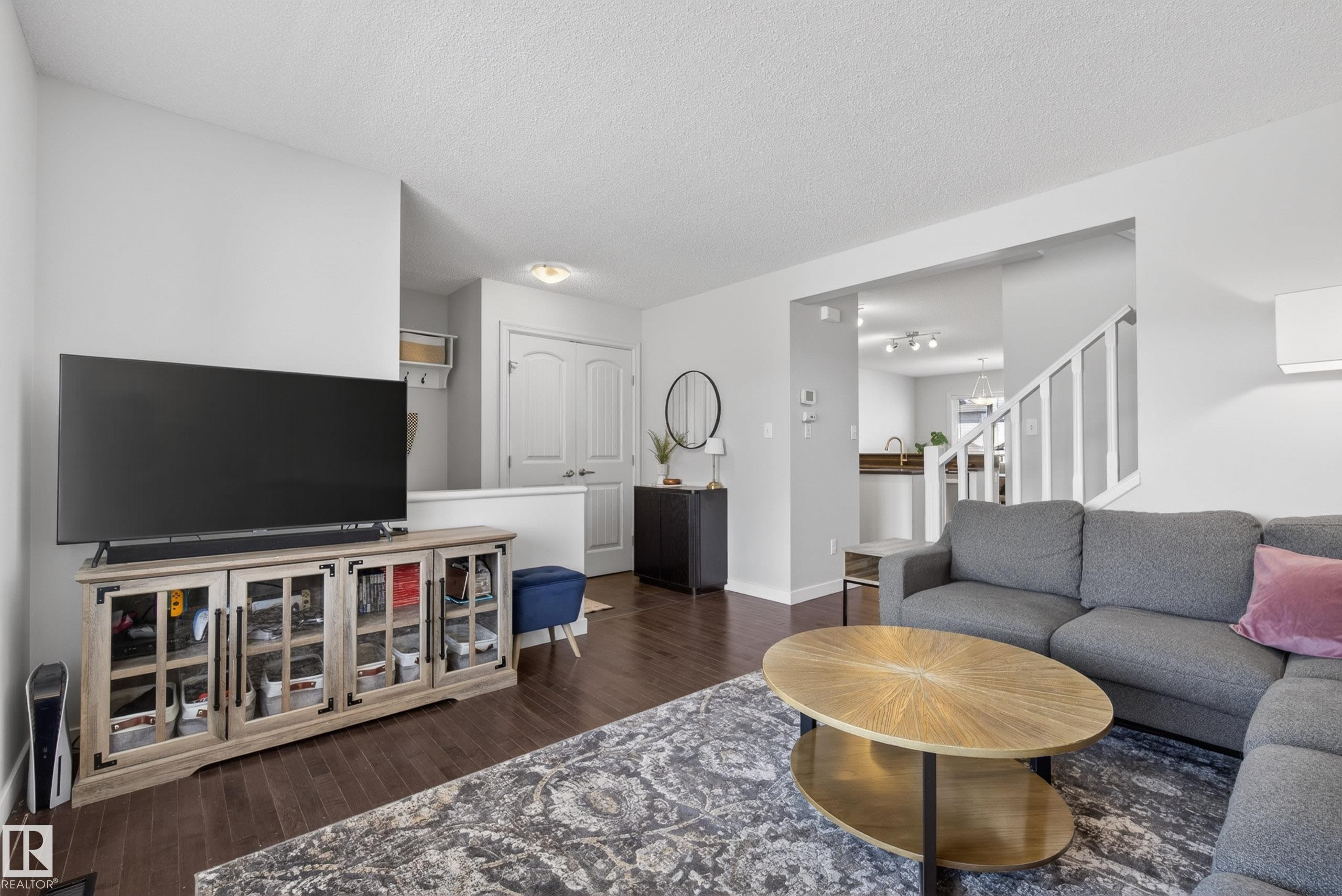 Living area featuring dark wood-finish flooring, white walls, and an open layout - 1148 35 Avenue, Edmonton, AB - Indoor Photo Showing Living Room