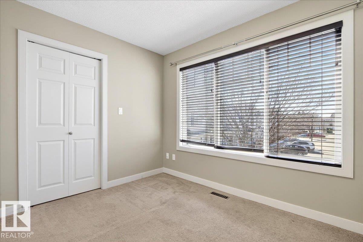 Spacious room featuring neutral paint tones, light-colored carpeting, and white trim - 18 6032 38 Avenue, Edmonton, AB - Indoor Photo Showing Other Room