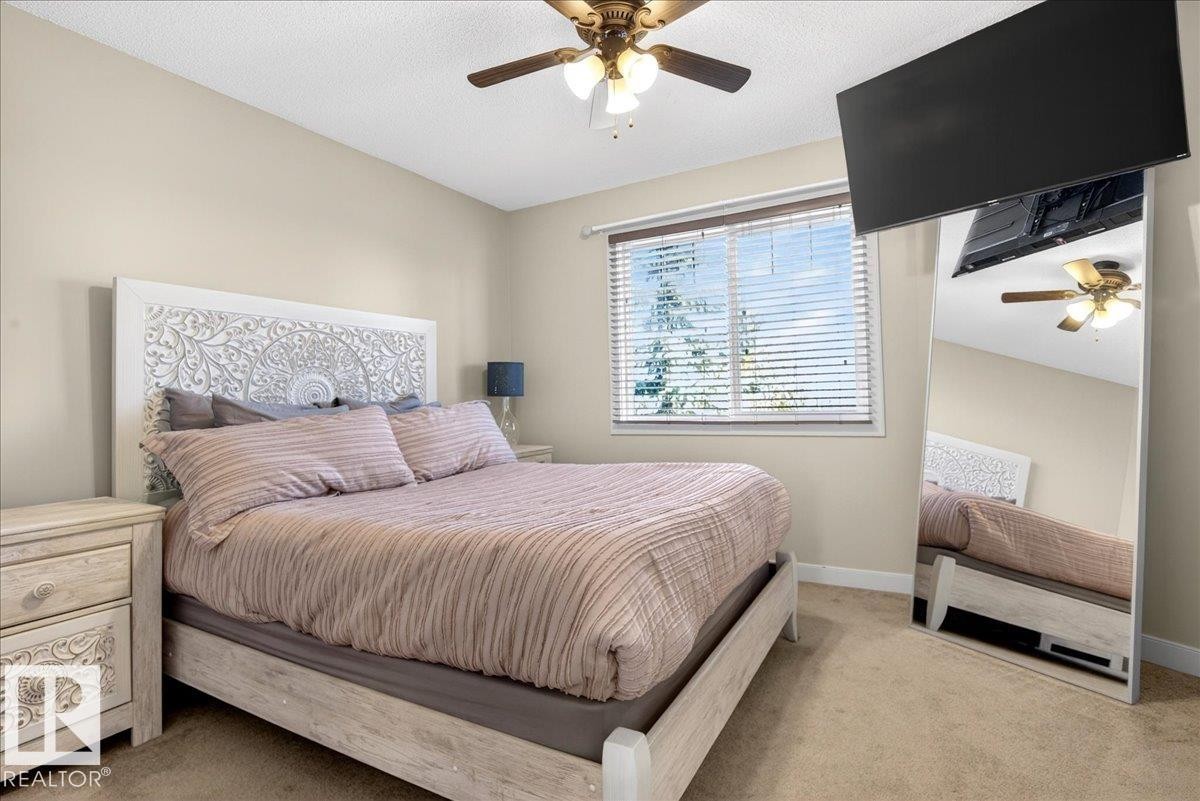 Bedroom featuring neutral wall paint, carpet flooring, a ceiling fan with integrated lighting, and a window with blinds - 18 6032 38 Avenue, Edmonton, AB - Indoor Photo Showing Bedroom