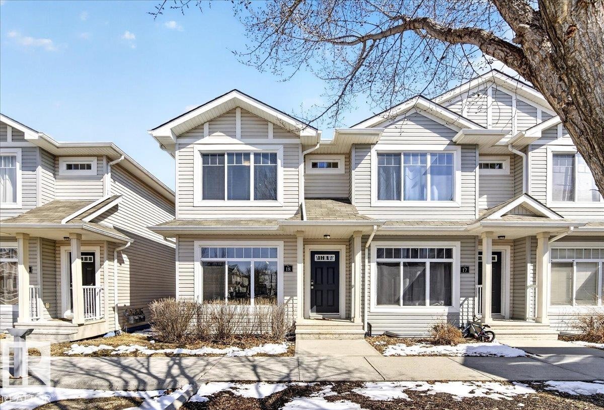 Townhome exterior with light-colored siding, contrasting trim, and multiple large windows - 18 6032 38 Avenue, Edmonton, AB - Outdoor With Facade